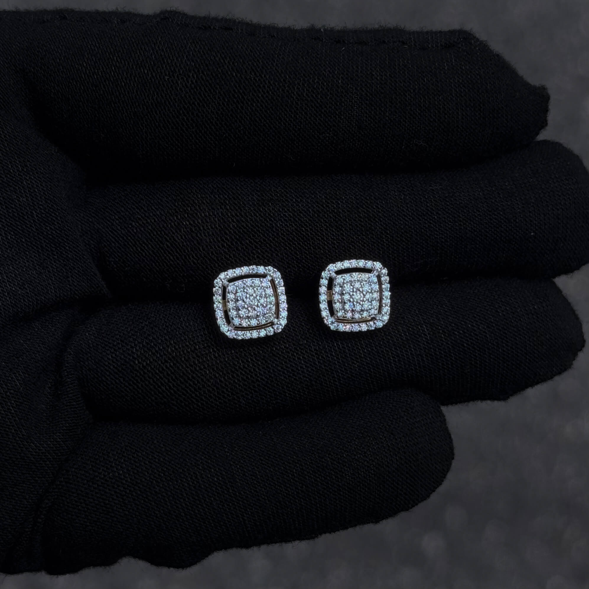 Small square sterling silver Moissanite cluster earrings with halo detail displayed on black glove.
