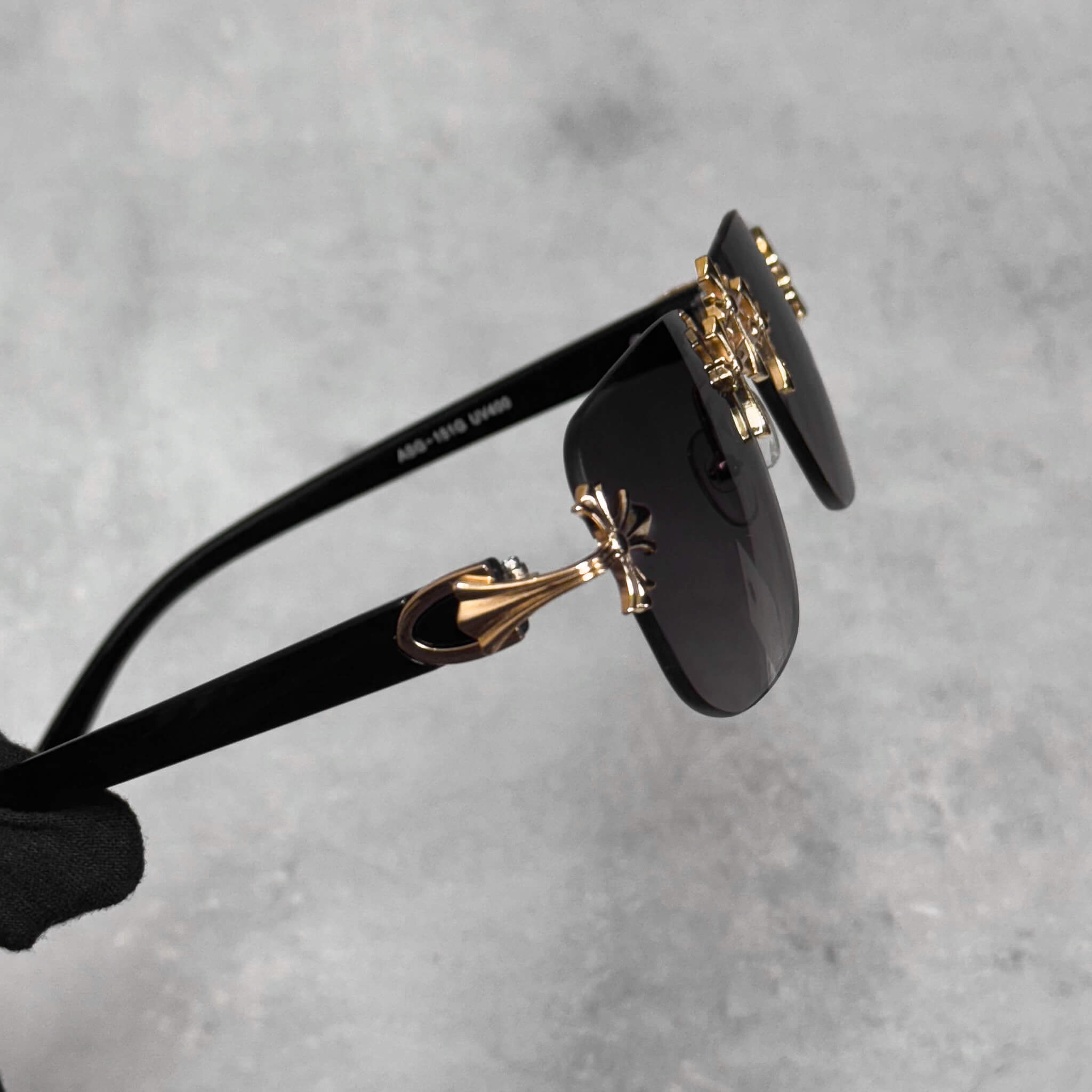 Black lens Triple Cross Sunglasses featuring gold cross temple accents and sleek black arms.