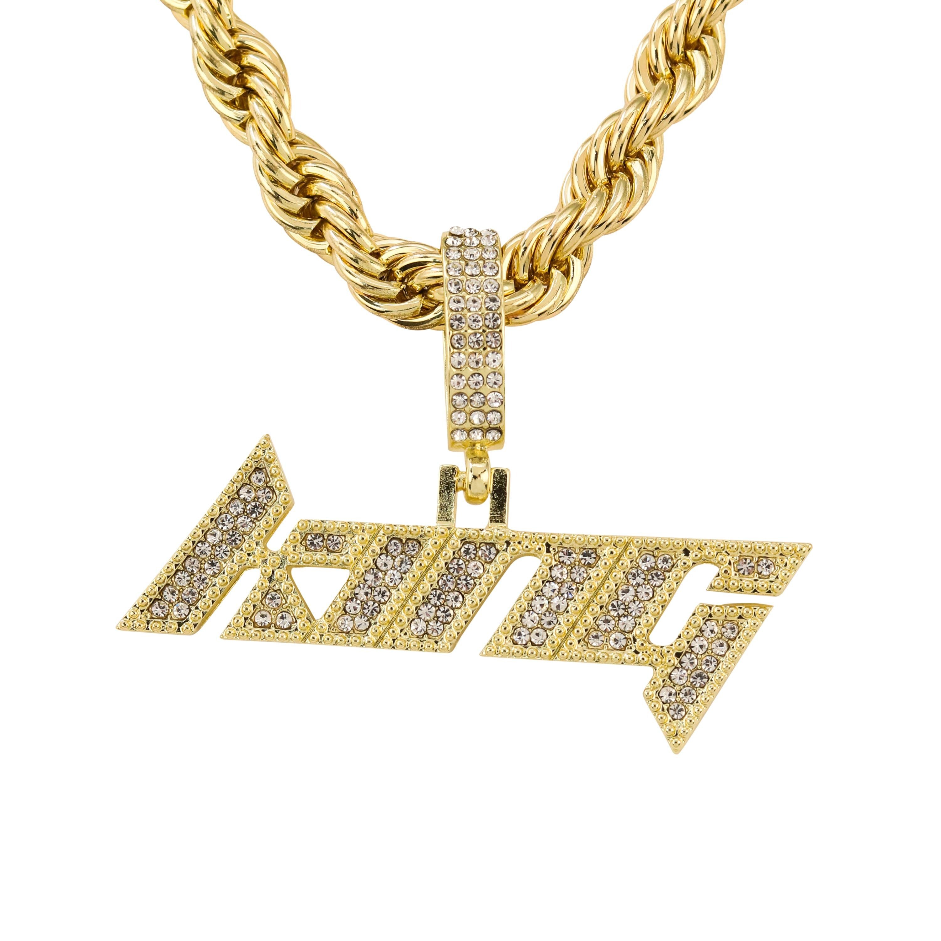 Close-up gold iced out “King” pendant with clear stones, paired with bold rope chain.