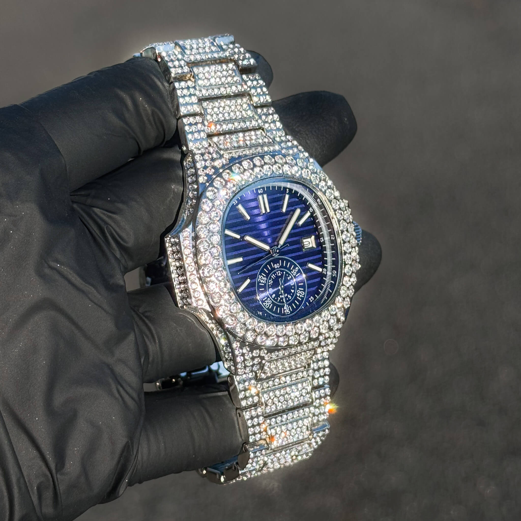 Men's 43mm iced out oblong watch with blue dial, diamond bezel, and fully stone-set bracelet.