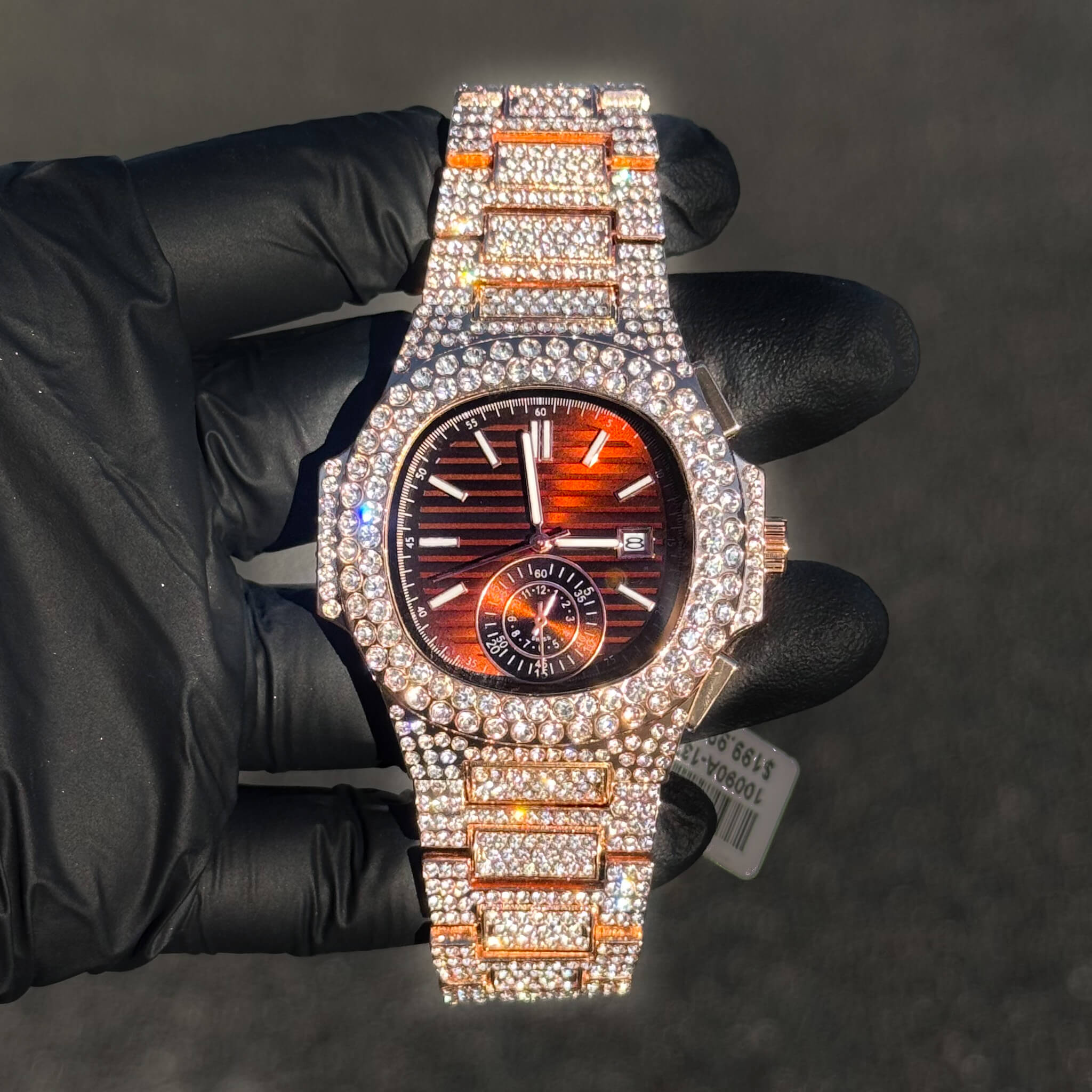 Men's 43mm iced out oblong watch with ruby red dial, diamond bezel, and fully iced-out bracelet.