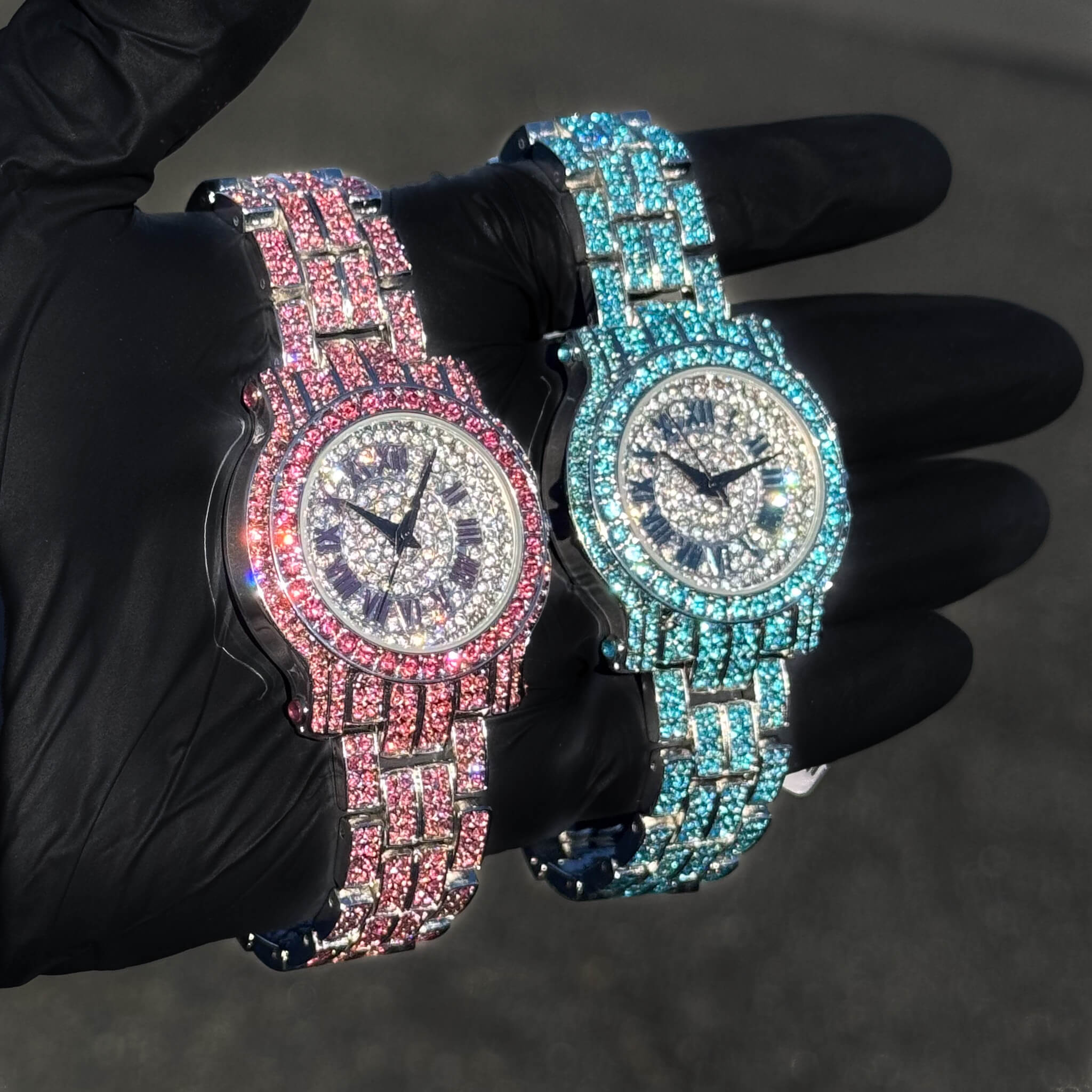 Side view of pink and blue iced 35mm women’s diamond watches featuring Roman dial design.