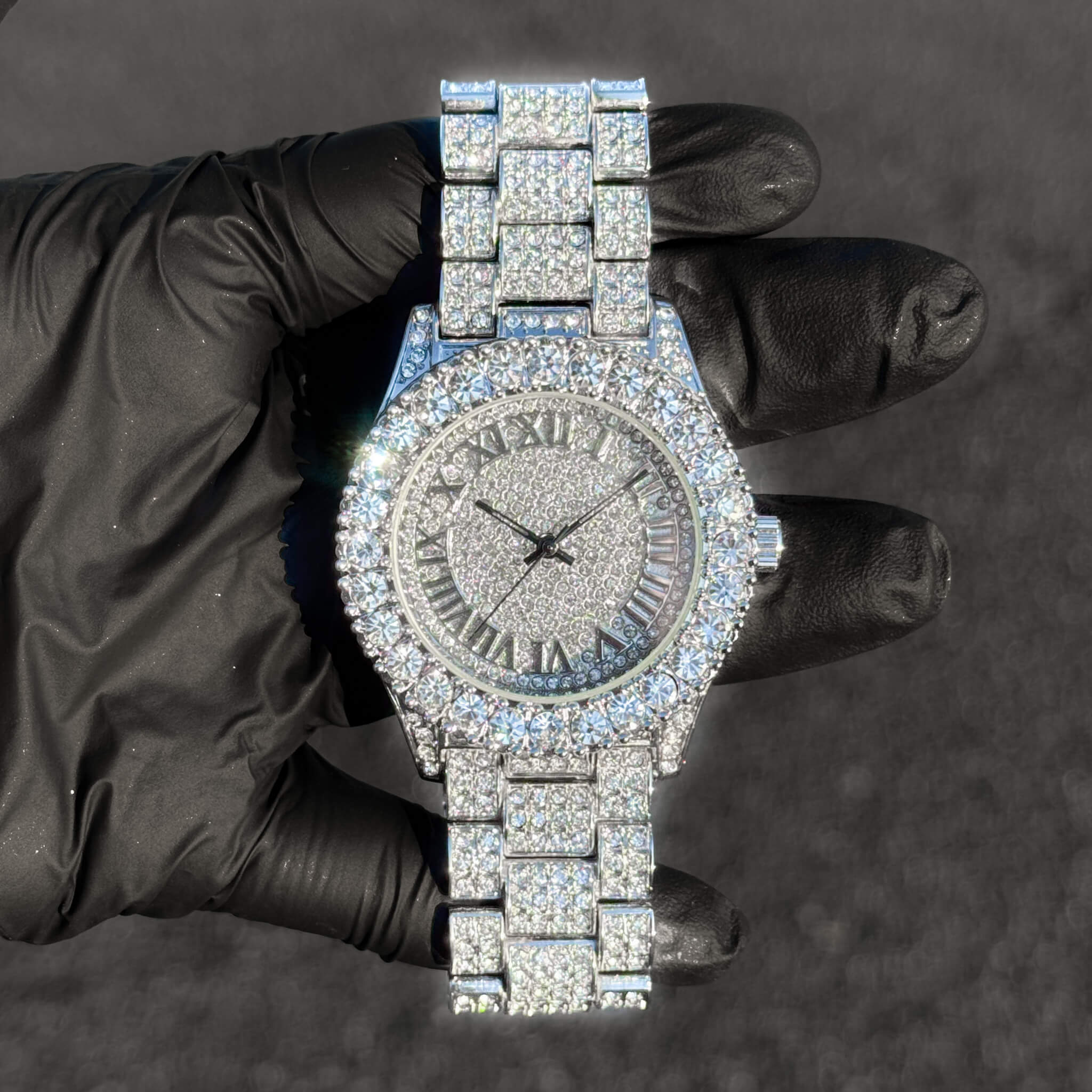 Silver 44mm women’s diamond watch featuring a fully iced Roman round dial and quartz movement.