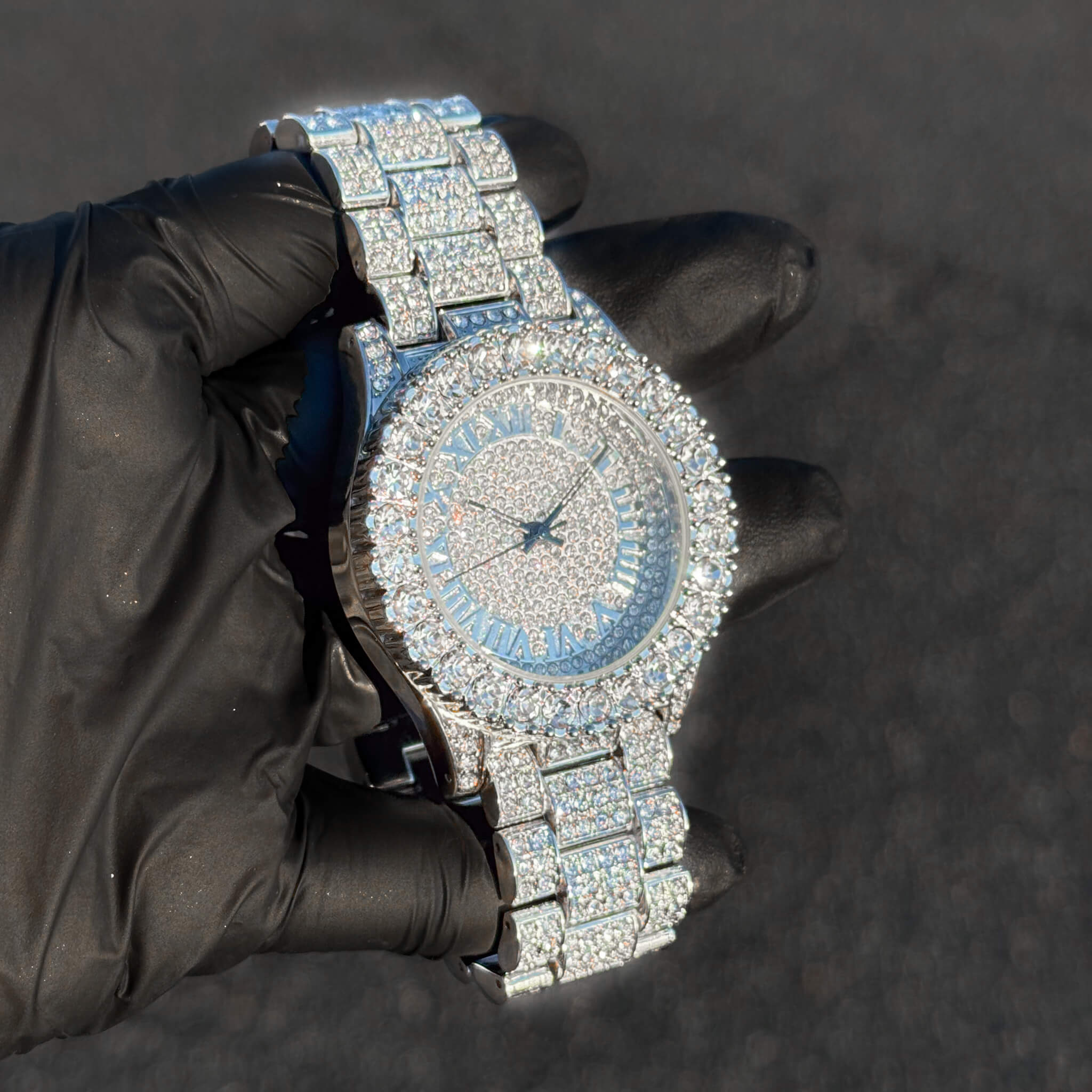 Angled view of silver 44mm women’s iced diamond watch with Roman round dial and luxury bracelet design.