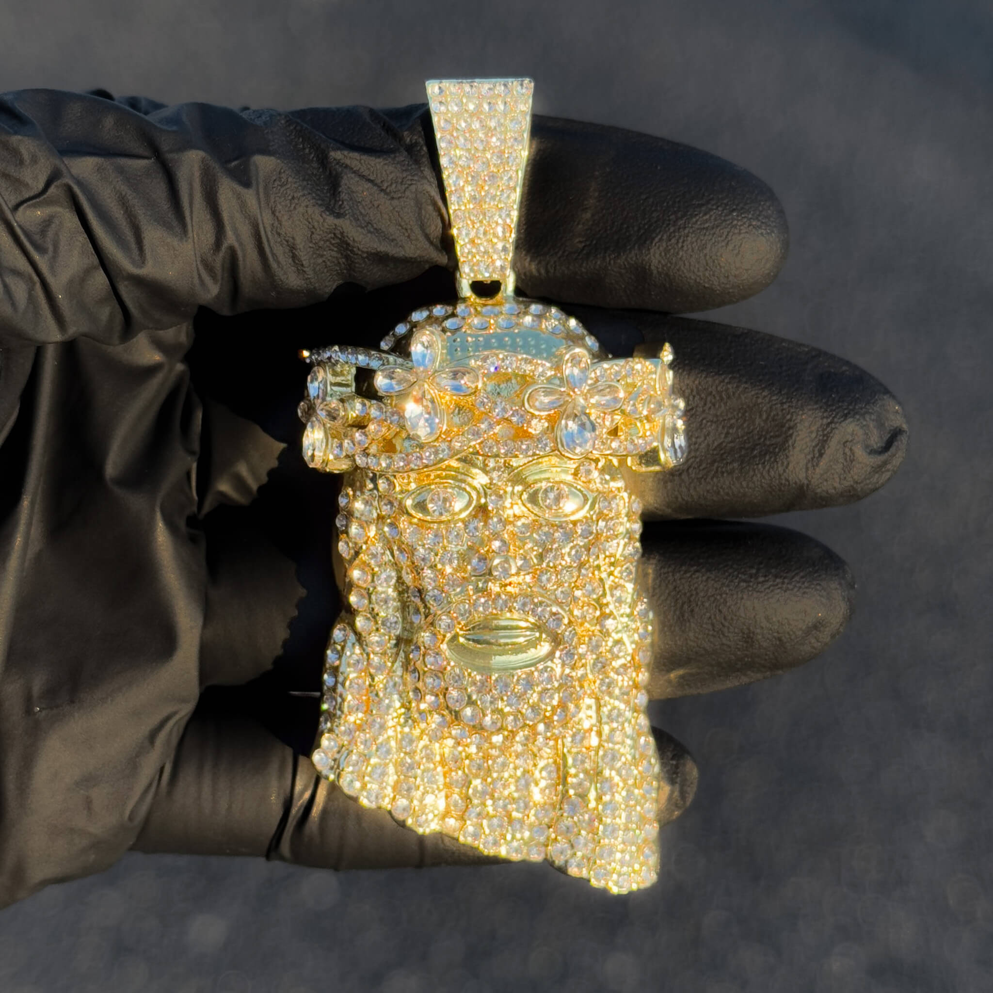 Large gold iced-out Jesus pendant with detailed floral crown.