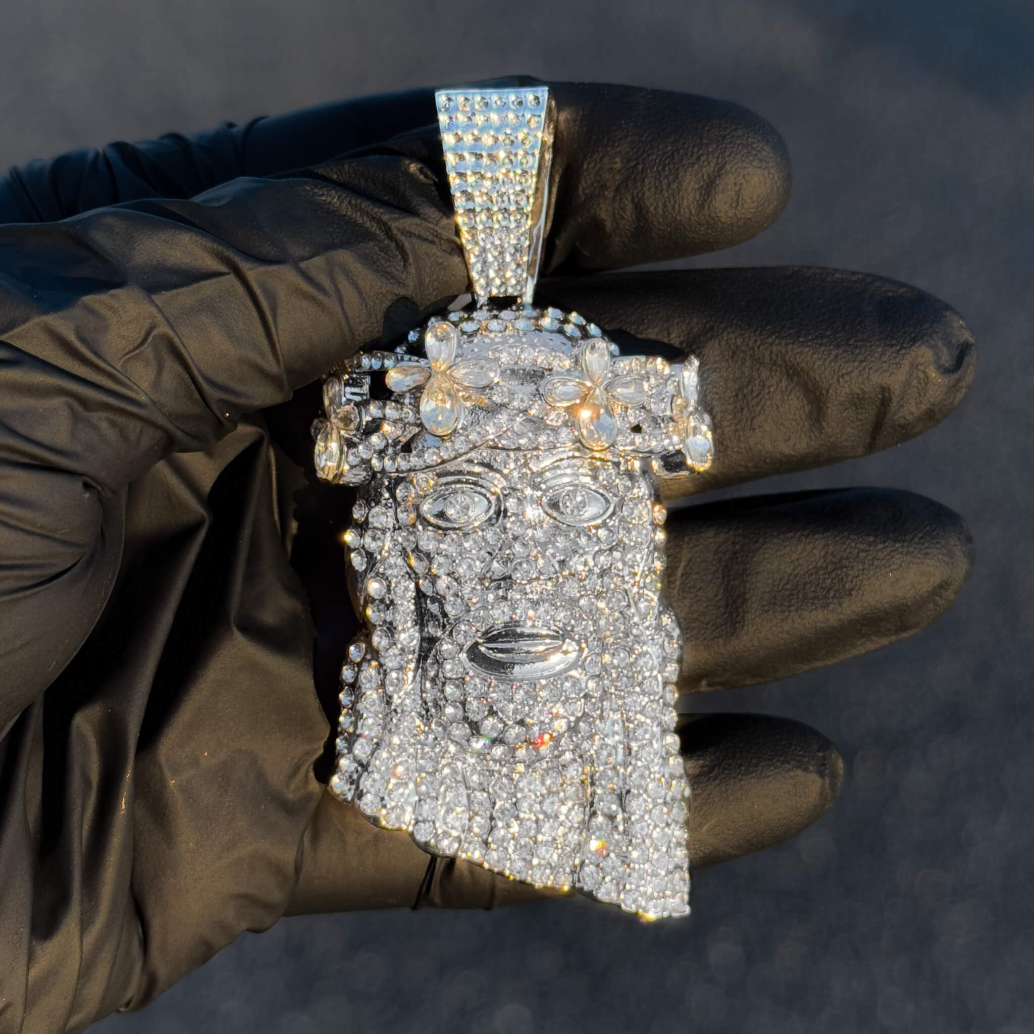 Large silver floral iced-out Jesus pendant with clear stones shown close-up for detail clarity.