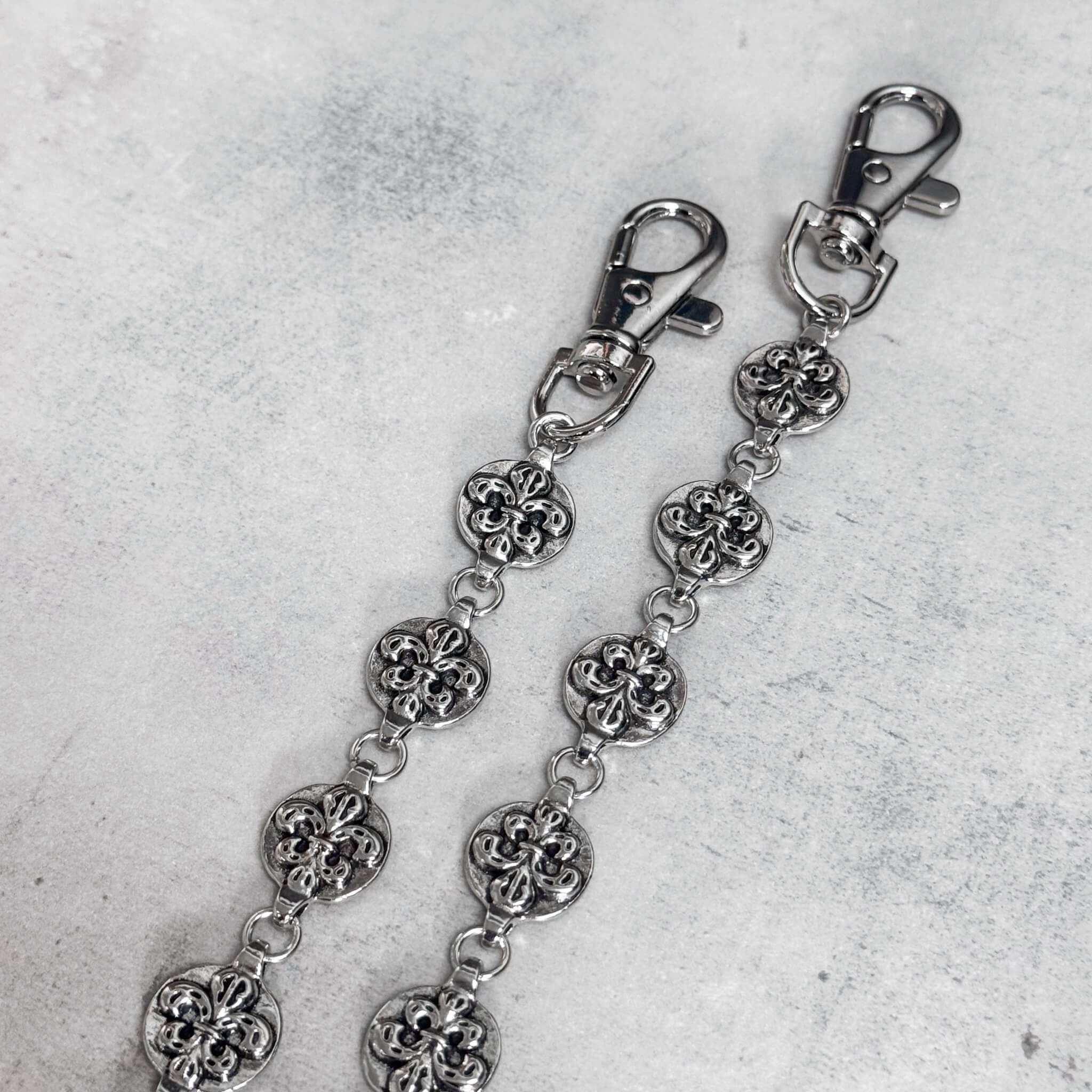 Close-up of Round Cross Link Pant Chain showing textured silver cross links and metal clasps.