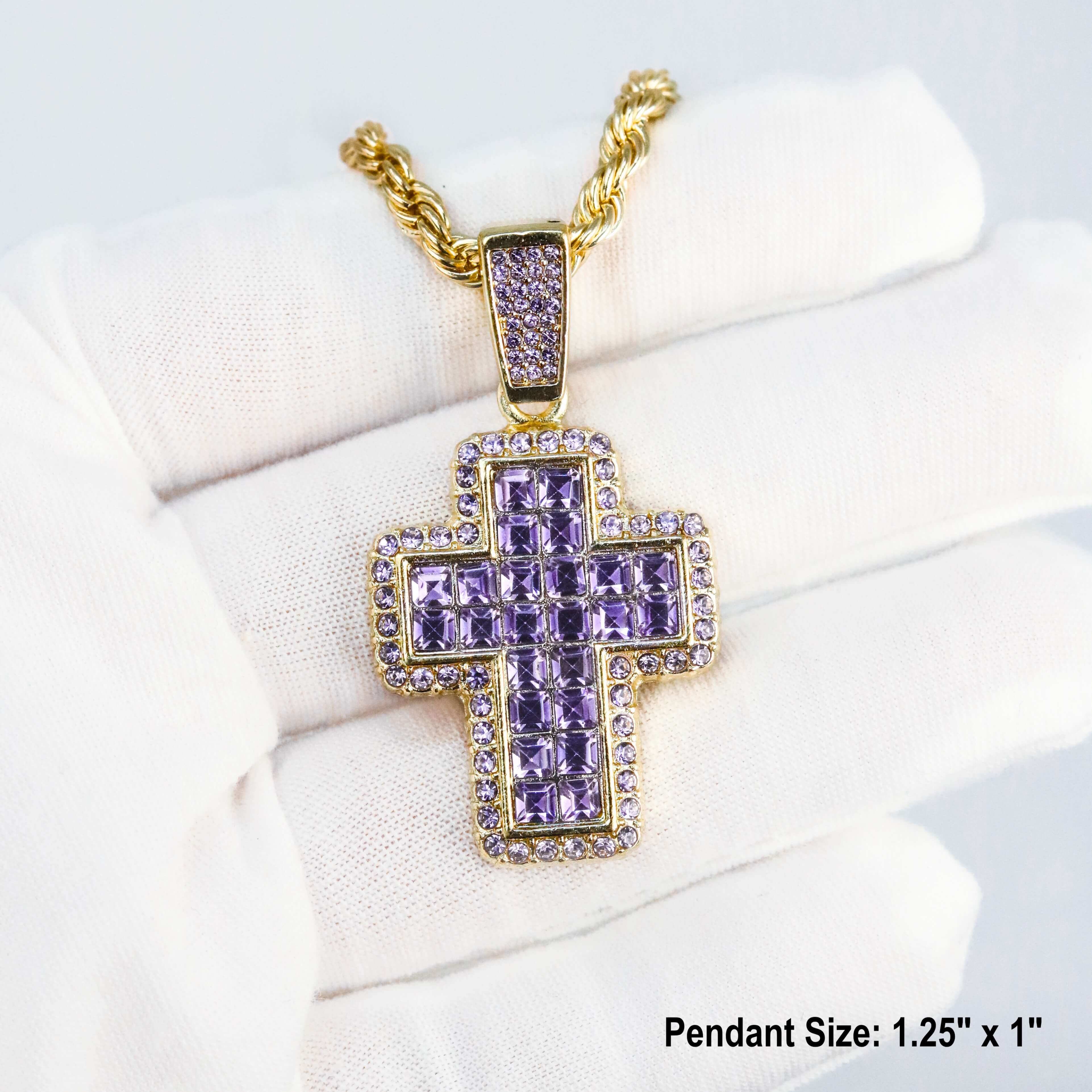 Gold iced-out purple cross pendant with square-cut stones on rope chain showcased in hand.