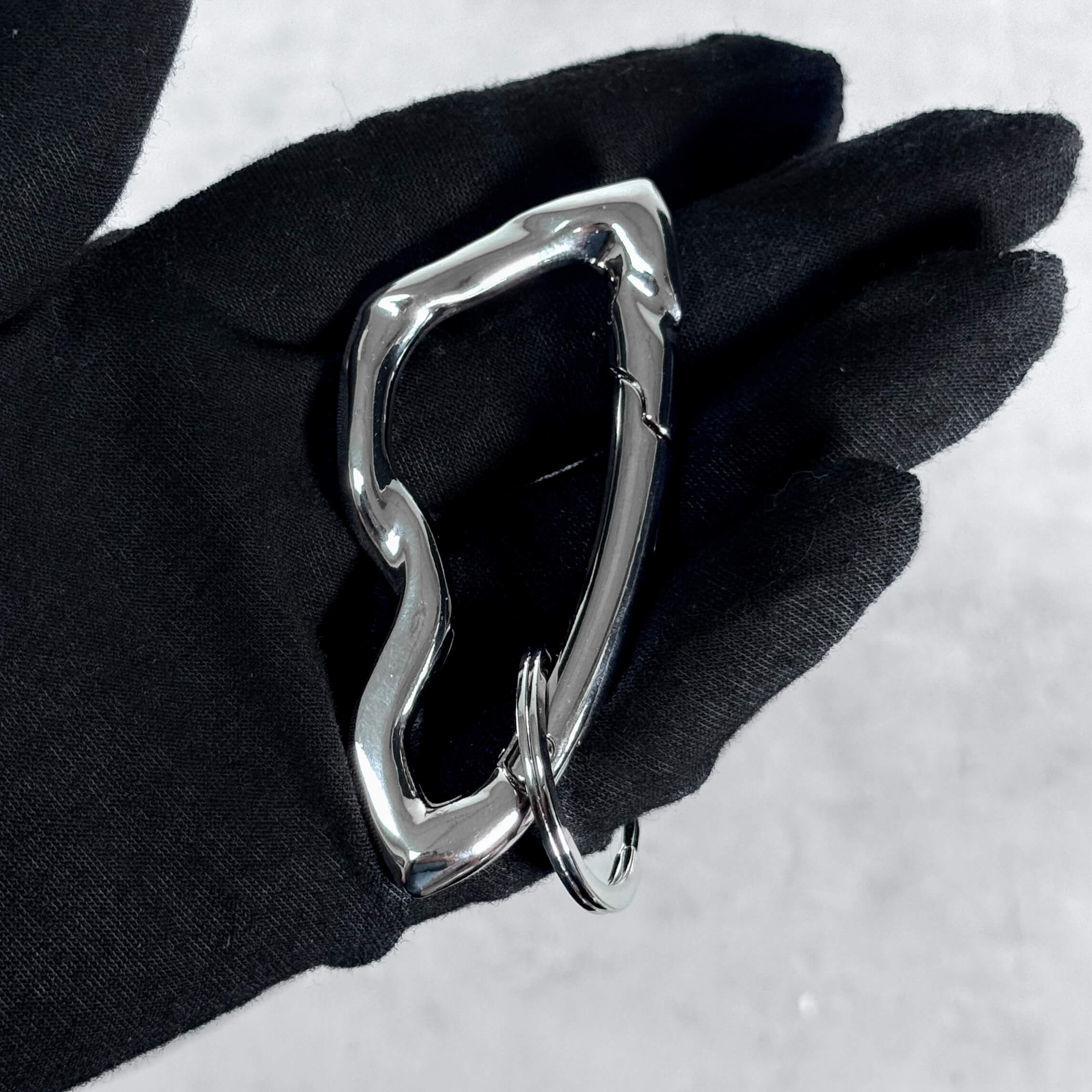 Angled view of silver Irregular Y2K carabiner keychain featuring fluid wavy frame and metal key ring.
