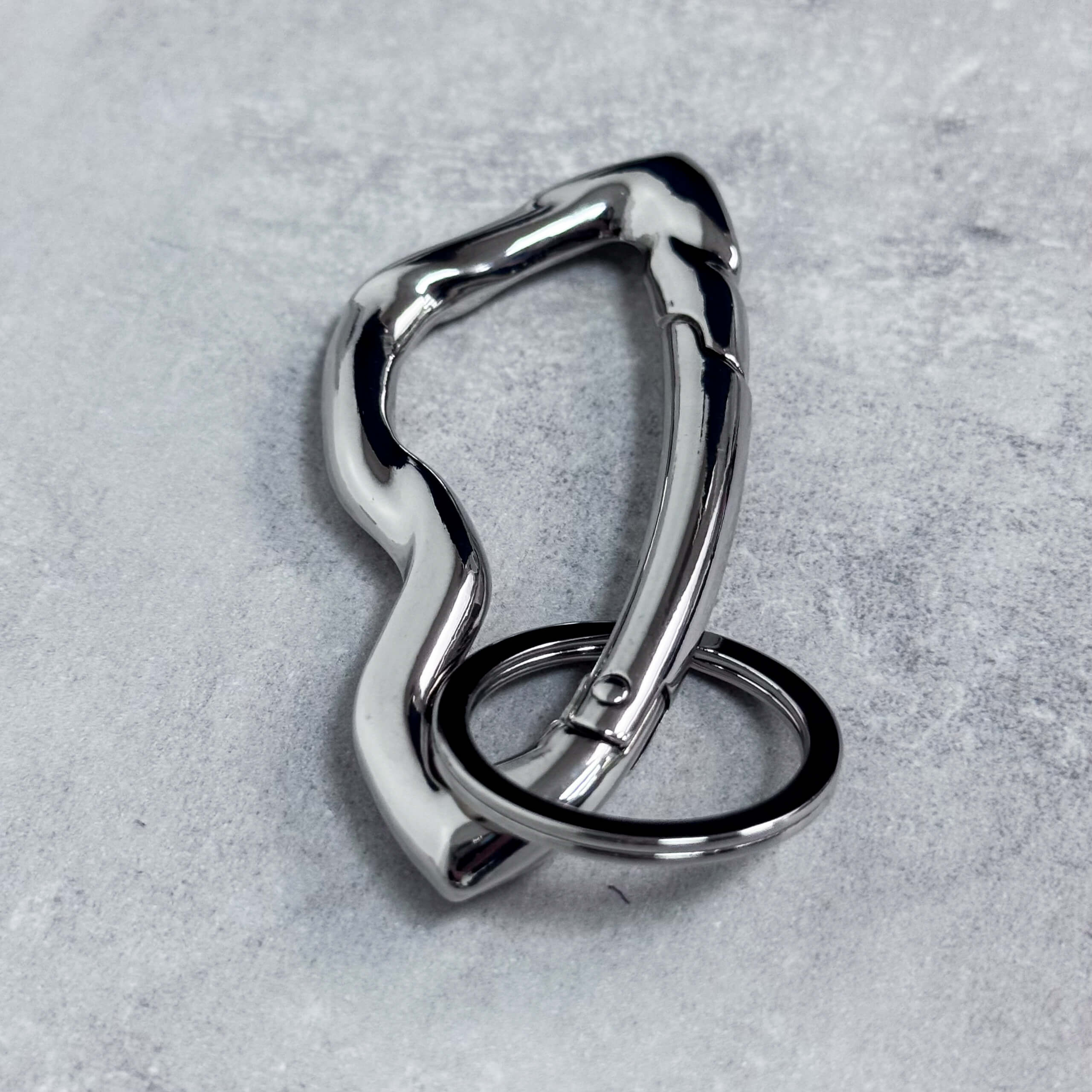 Close-up of silver Irregular Y2K carabiner keychain showcasing smooth wavy shape and sturdy key ring.