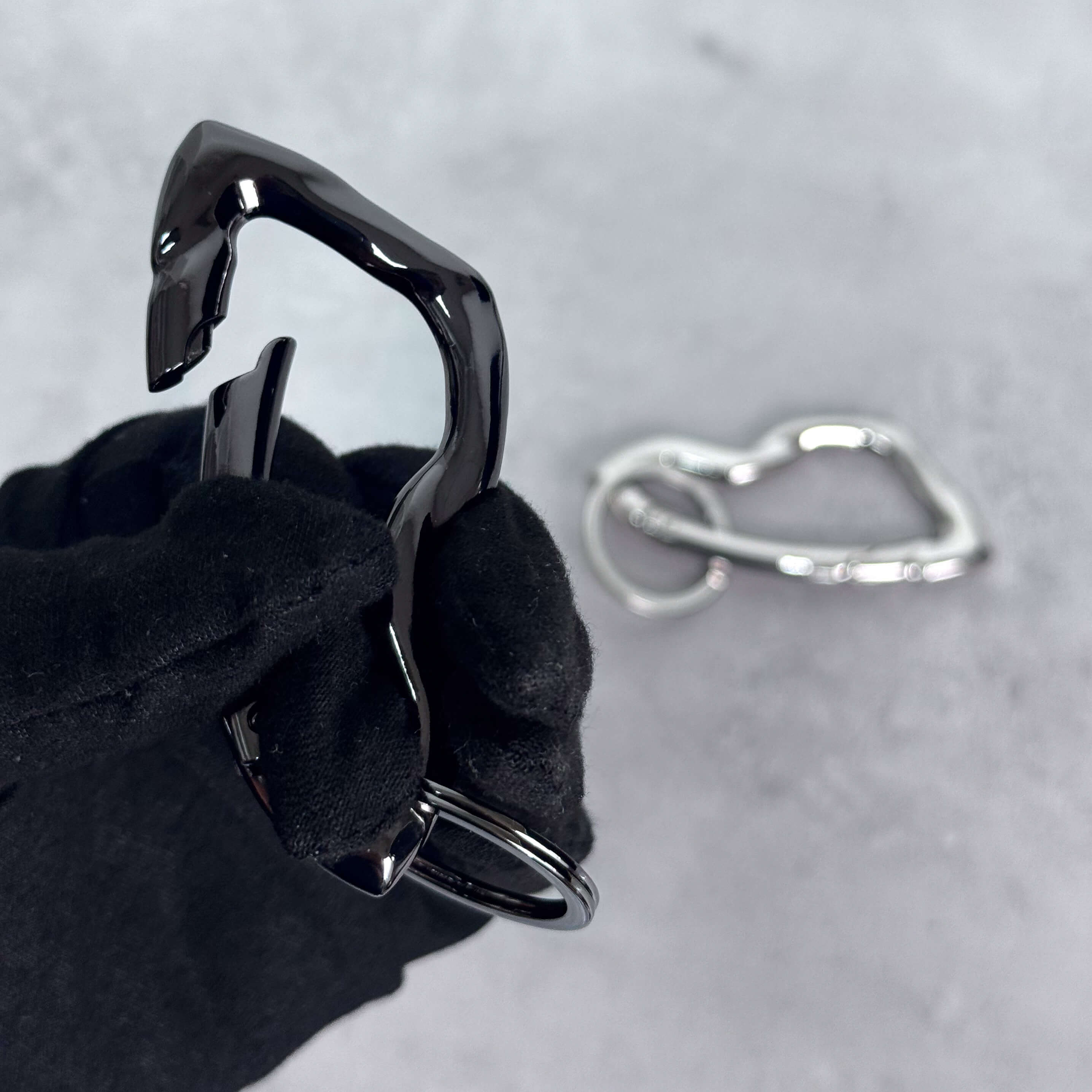 Black Irregular Y2K carabiner keychain shown mid-open, highlighting smooth curved metal latch design.