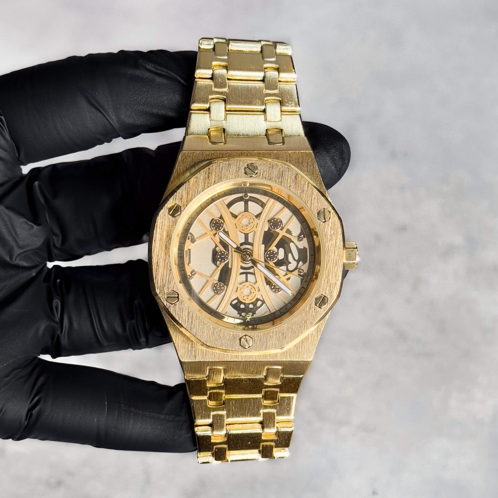 Men’s 40mm gold luxury watch with skeleton dial, brushed octagon bezel and metal bracelet.