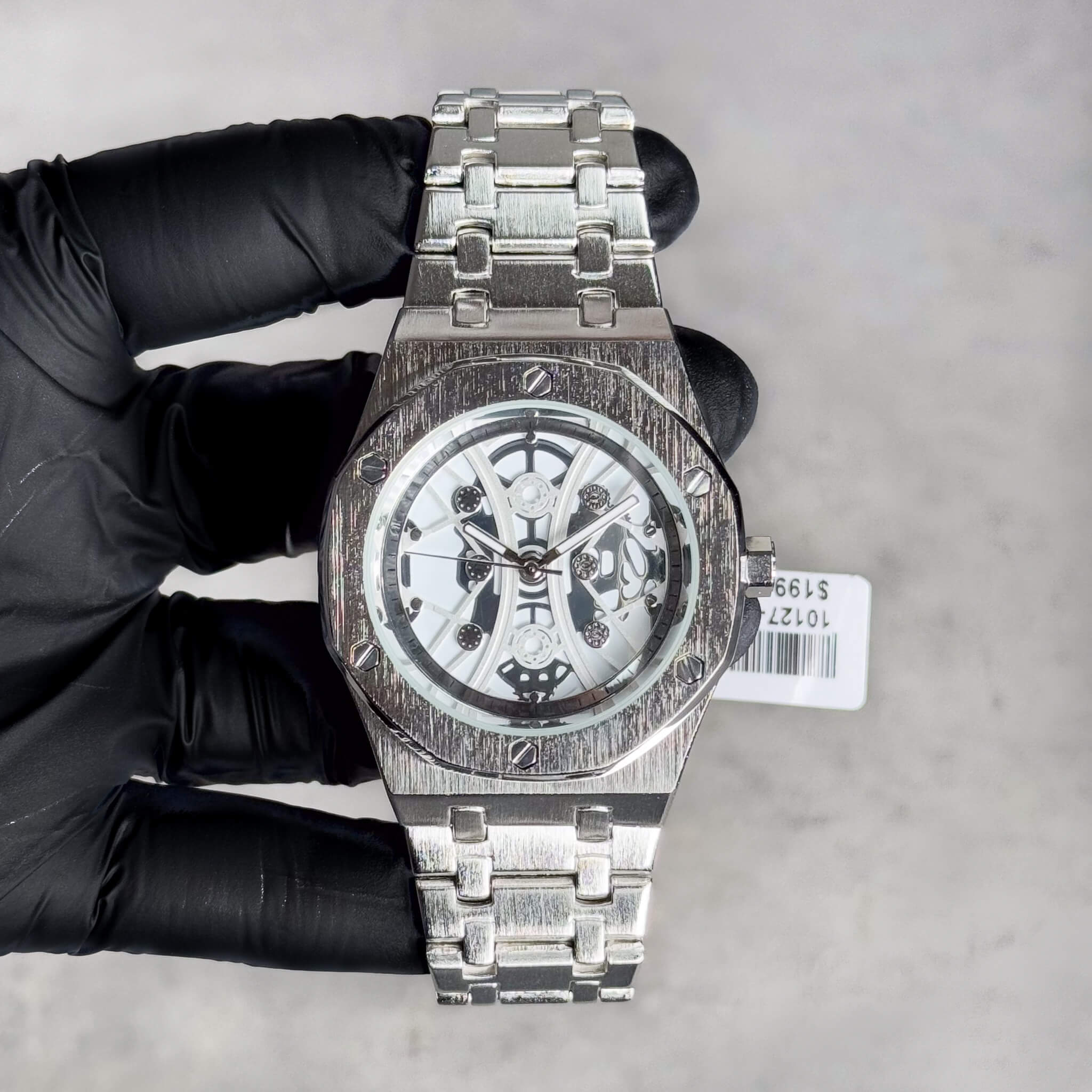 Men’s 40mm silver luxury watch featuring skeleton dial, octagon bezel and steel link band.