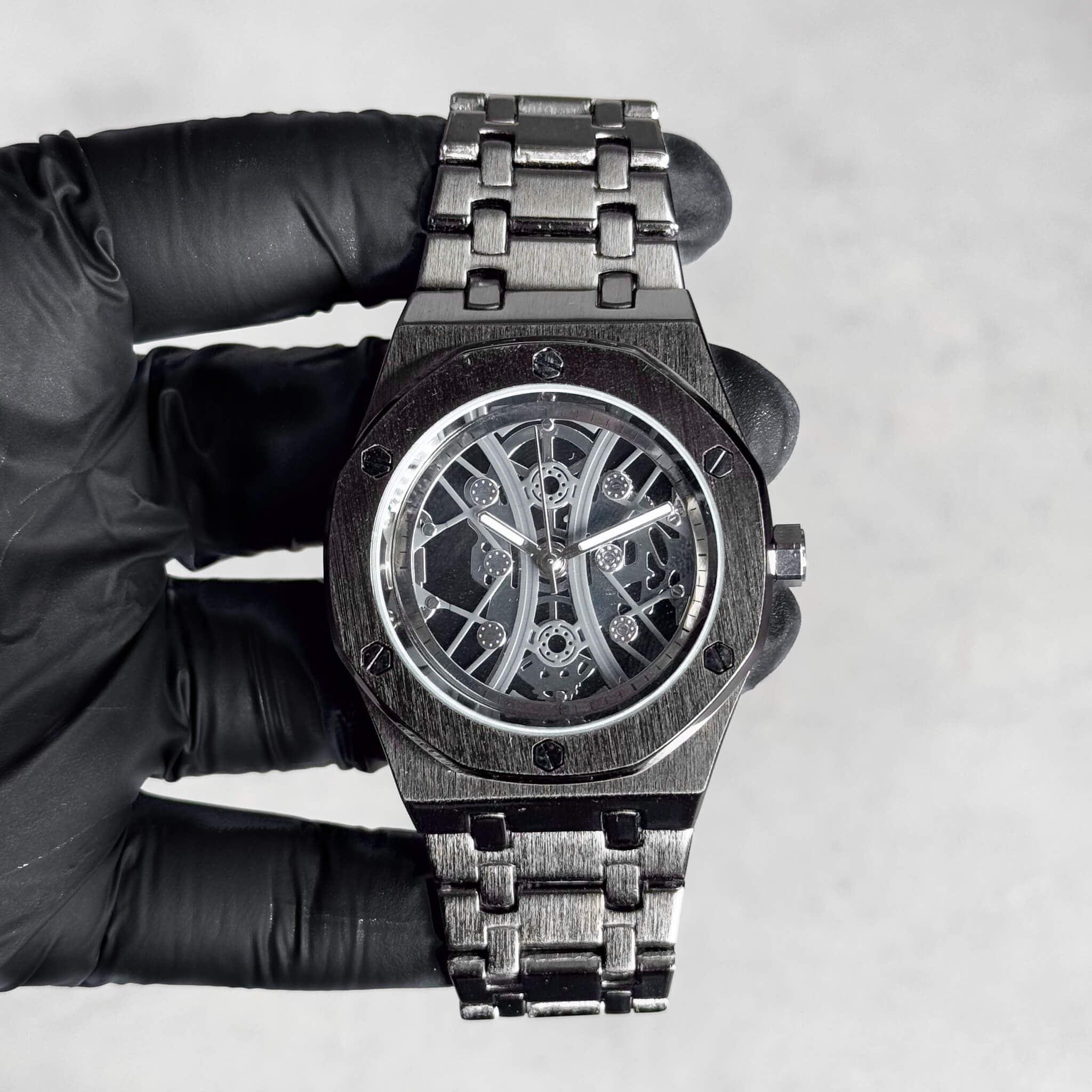 Men's 40mm black luxury skeleton dial watch with octagon bezel and brushed metal link band.