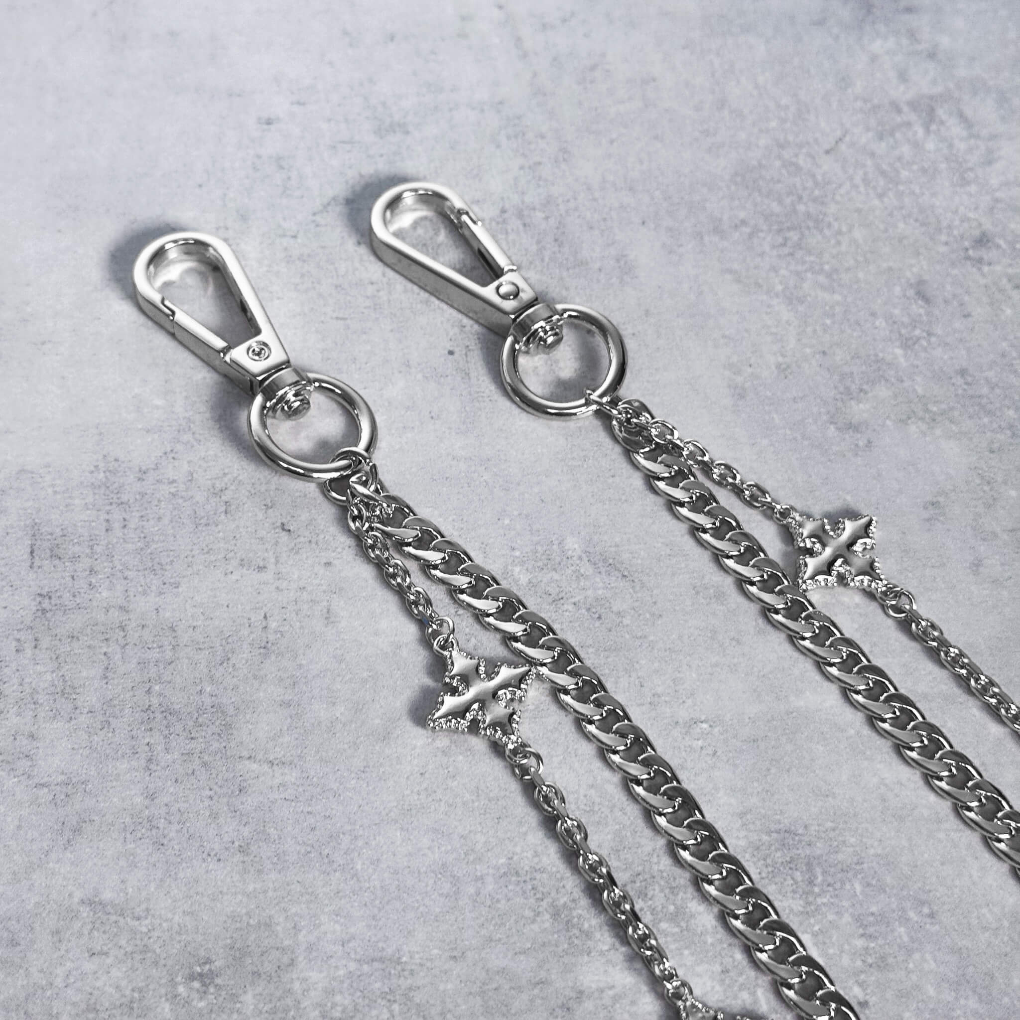 Close-up of silver Cuban with Cross Pant Chain showcasing layered links and star charms.