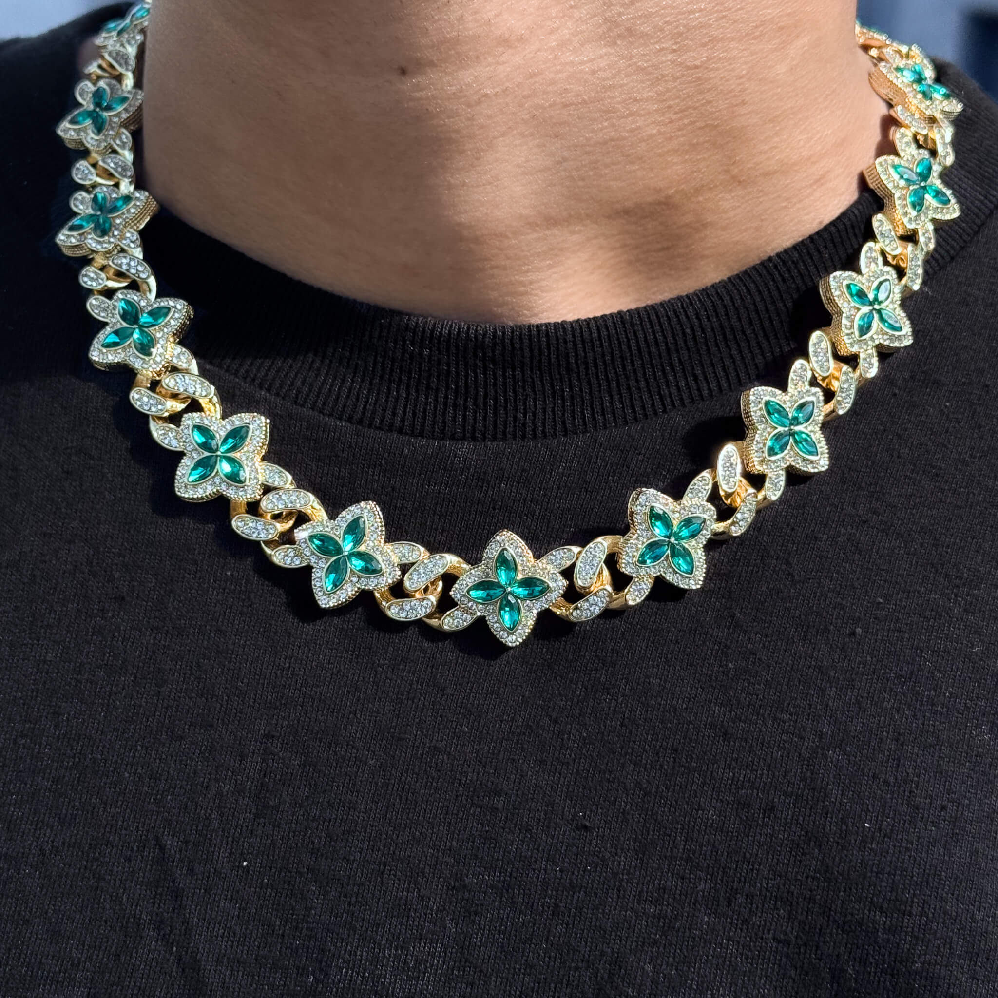 Gold Iced Clover Cuban Chain with green marquise stones, shimmering pavé detail on neck.