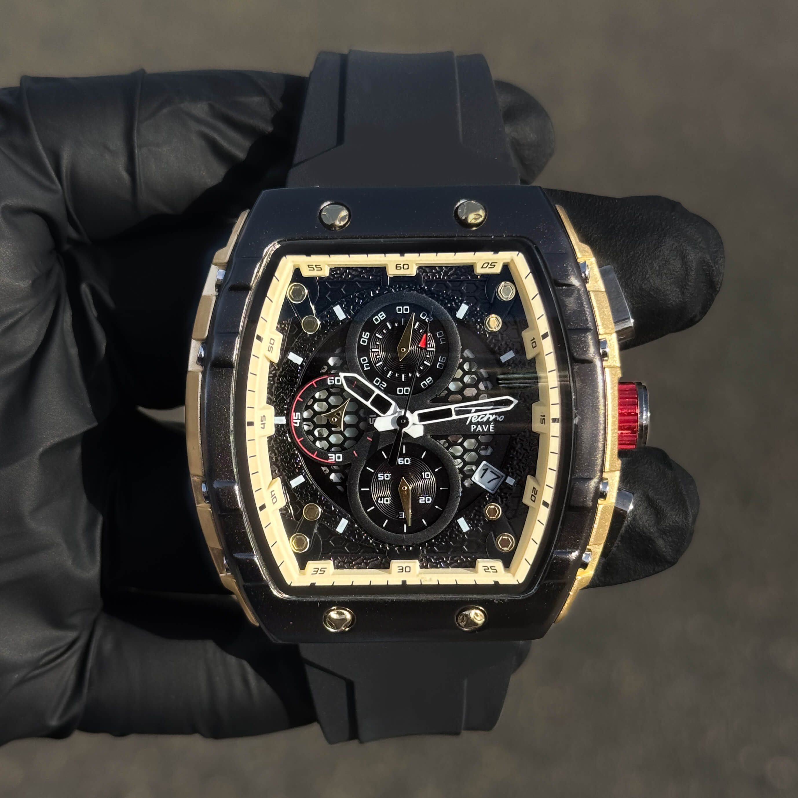 Men's 46mm sporty tonneau watch with black silicone band and gold-trimmed rugged chronograph dial.