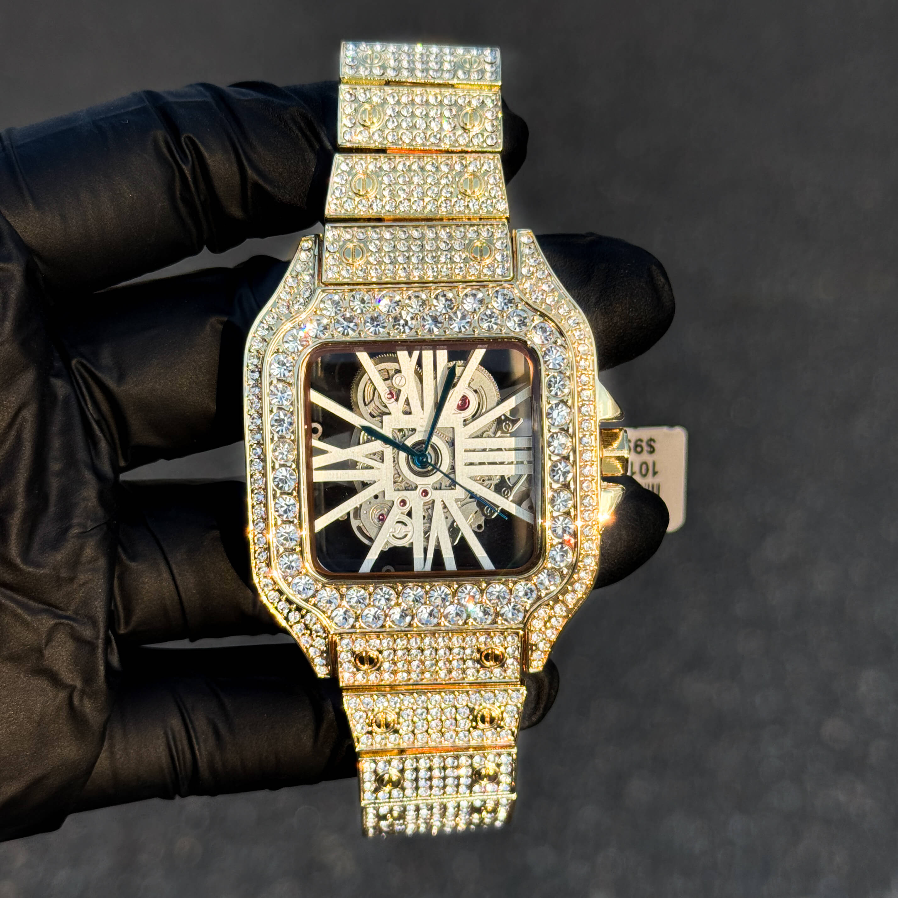 Gold fully iced out 40mm square men’s diamond watch with skeleton dial and quartz movement.