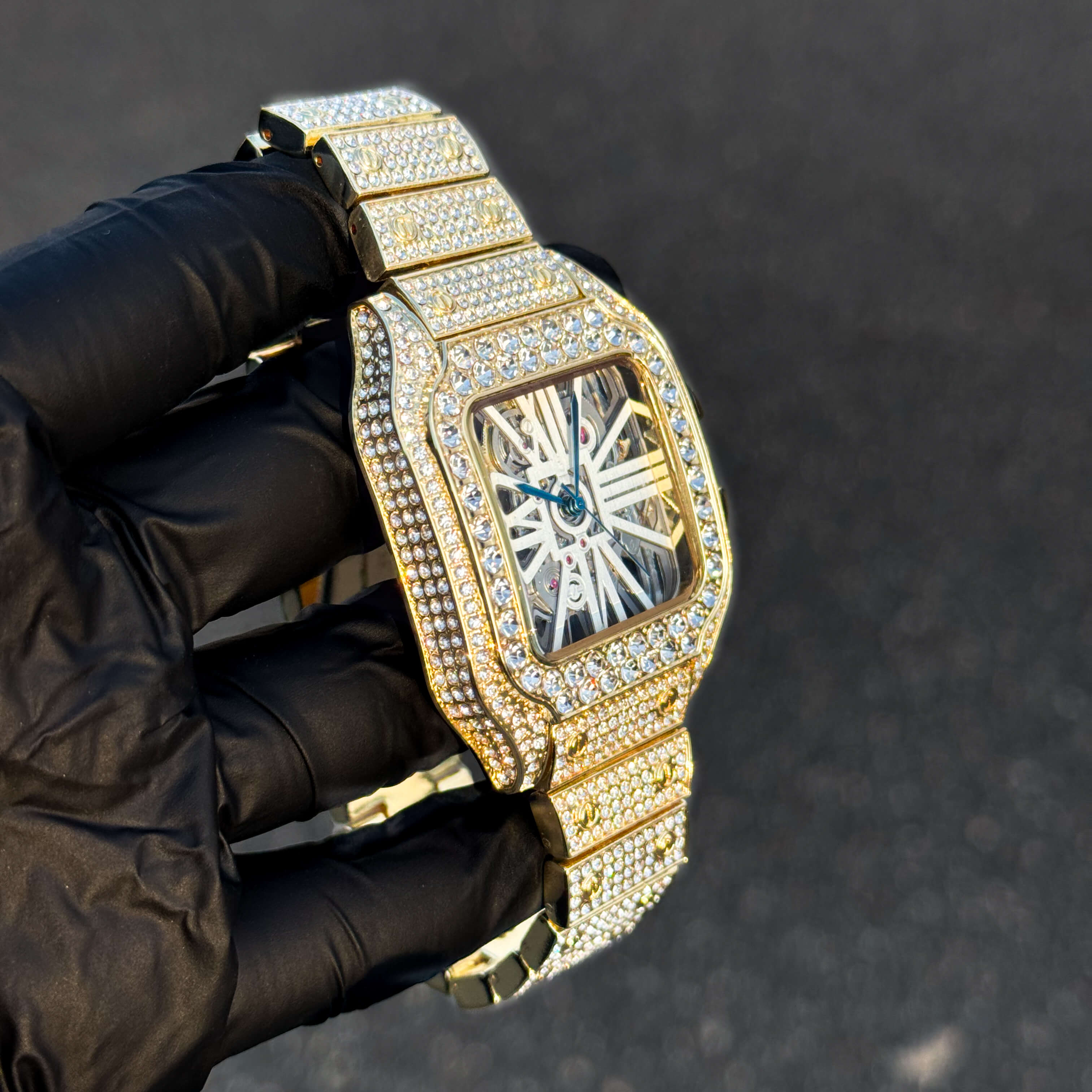 Side view of gold iced out 40mm square men’s diamond watch featuring a skeleton dial design.