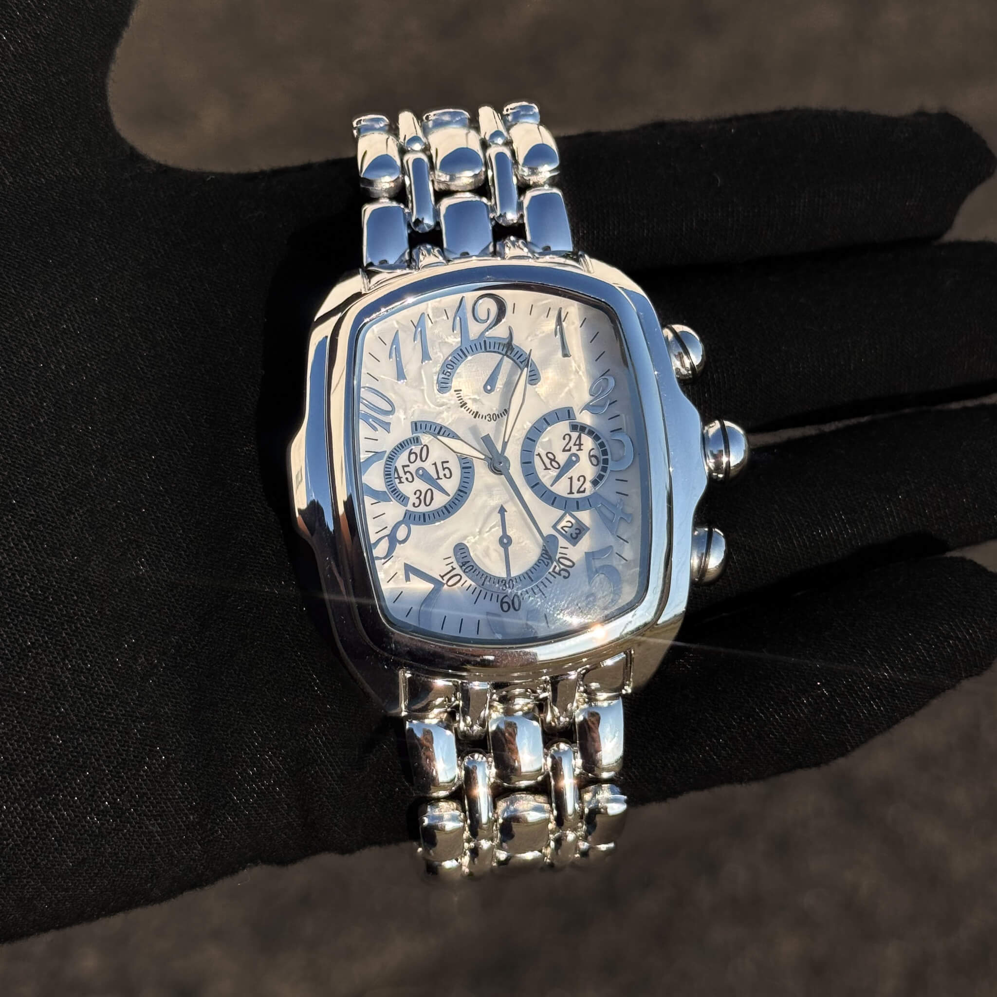 Men’s 43mm silver tonneau watch with white mother-of-pearl dial and stainless steel bracelet.