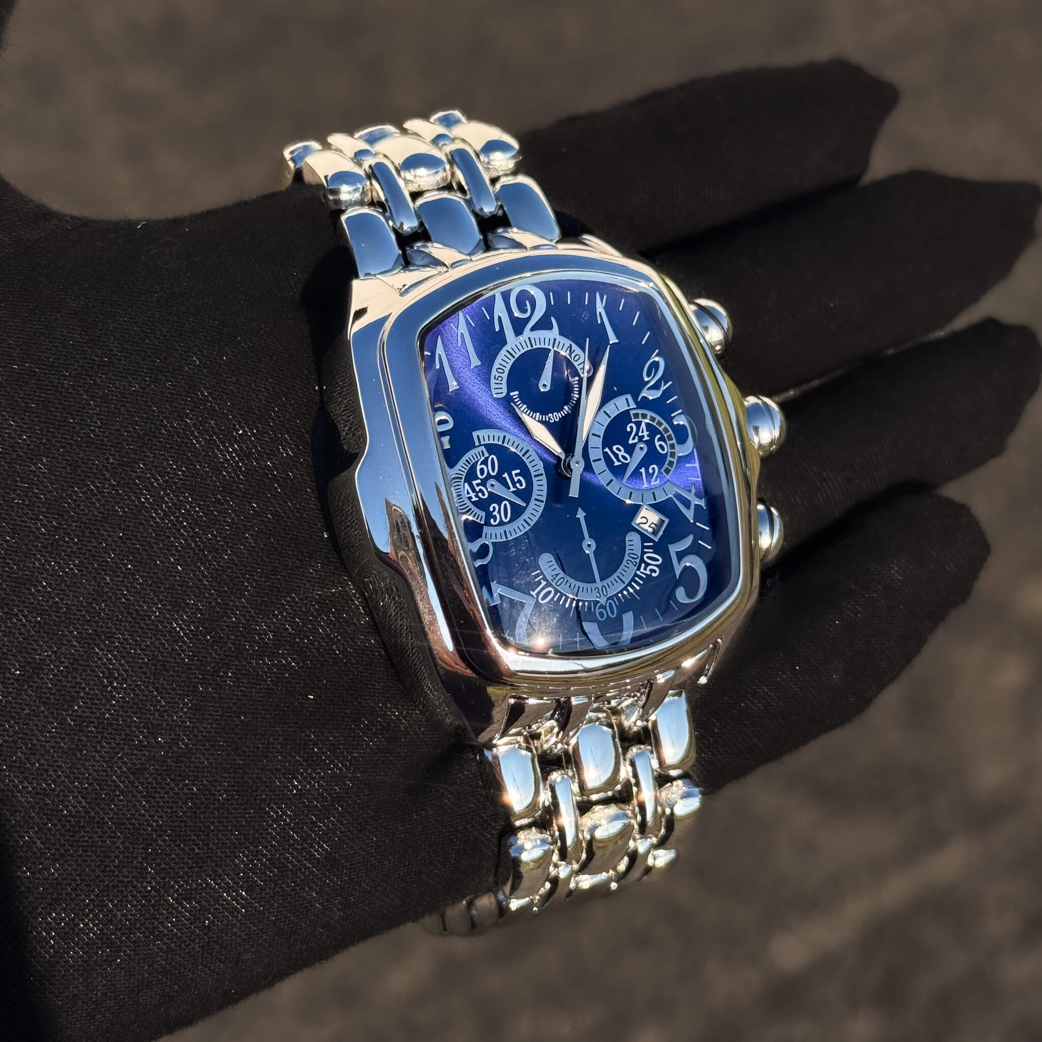 Men’s 43mm tonneau watch with blue dial and silver metal band, quartz movement.