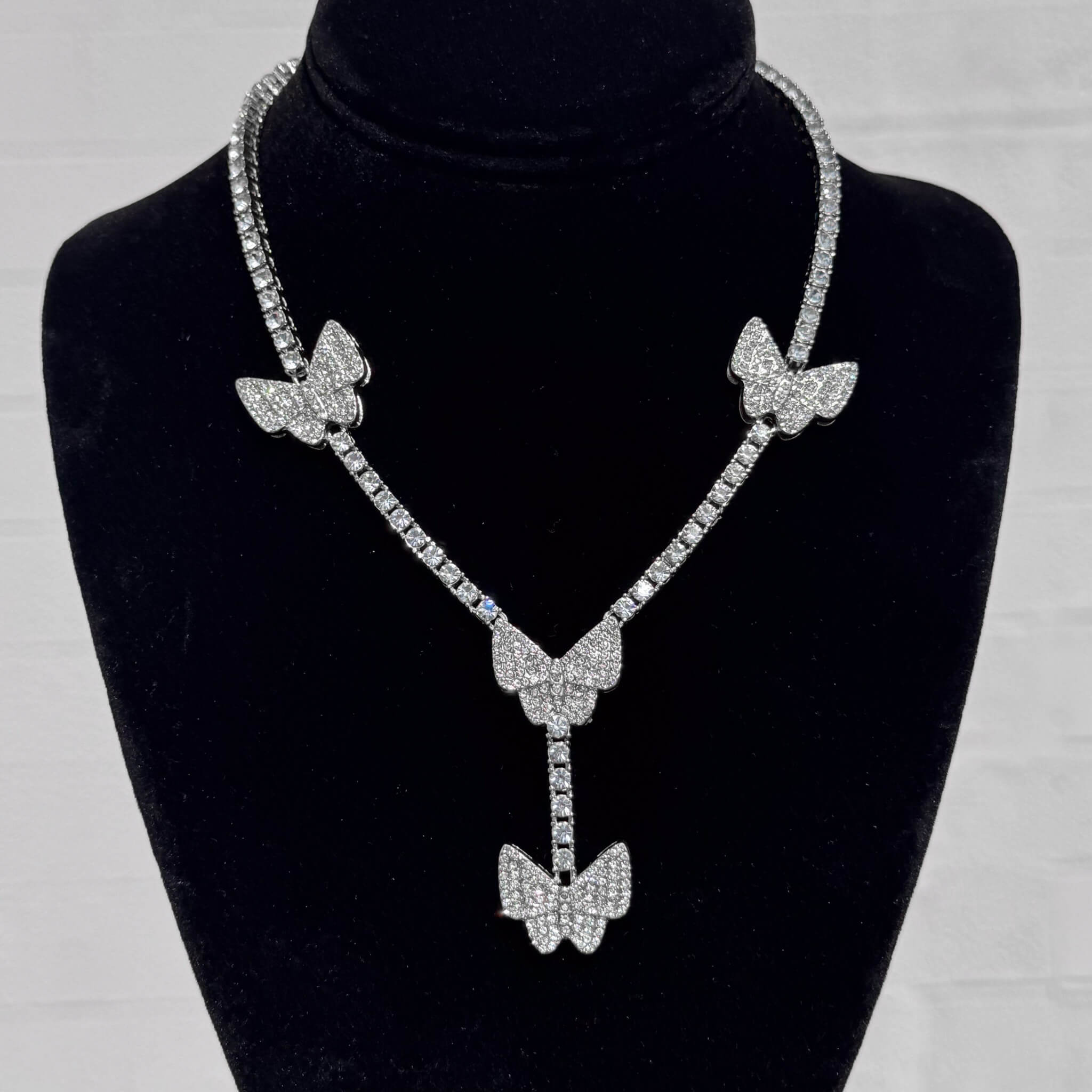 Silver Iced Butterfly Lariat Tennis Necklace with shimmering pavé butterfly pendants on black velvet.