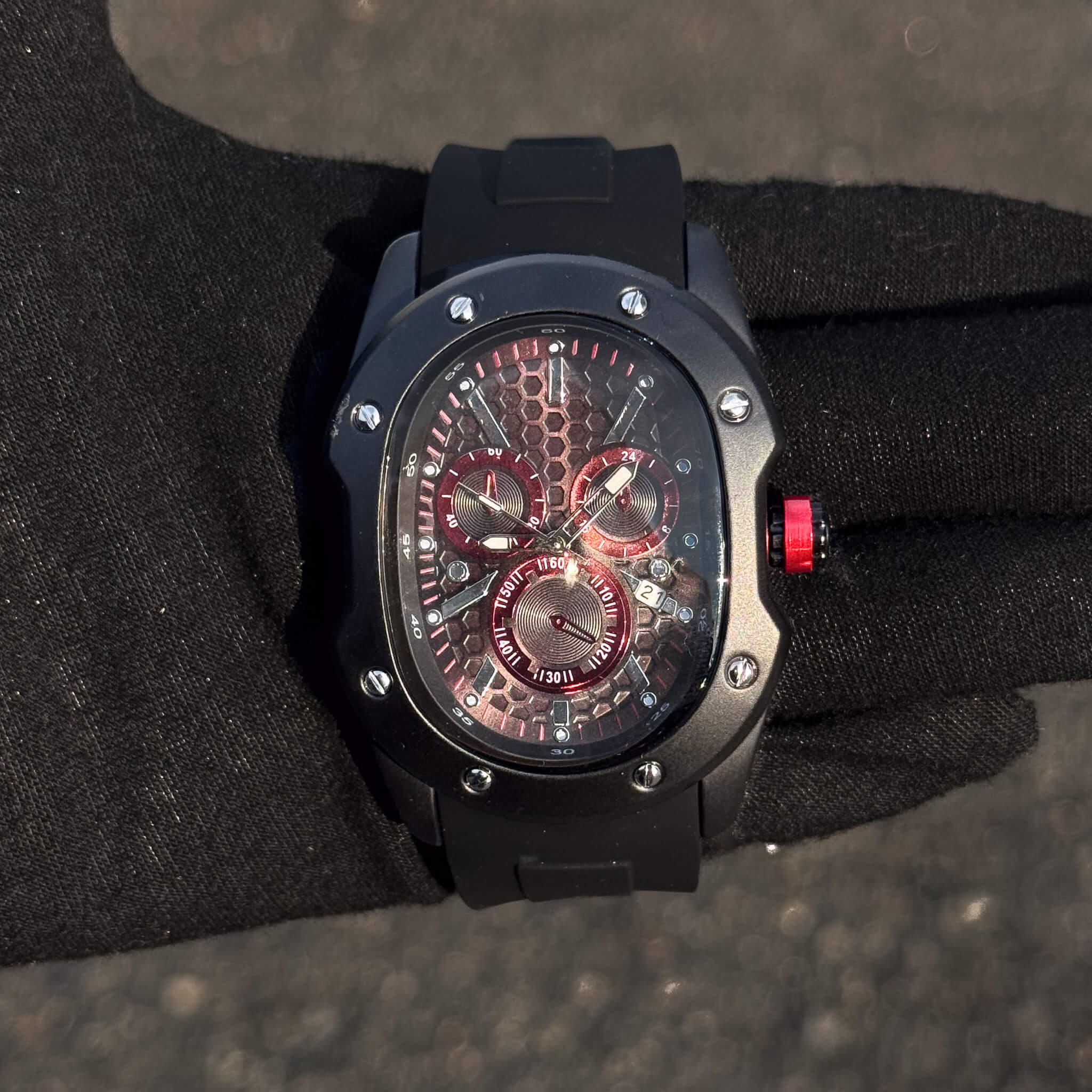 Men’s 40mm Classic Black Watch with red honeycomb dial, bold red crown, and date window.