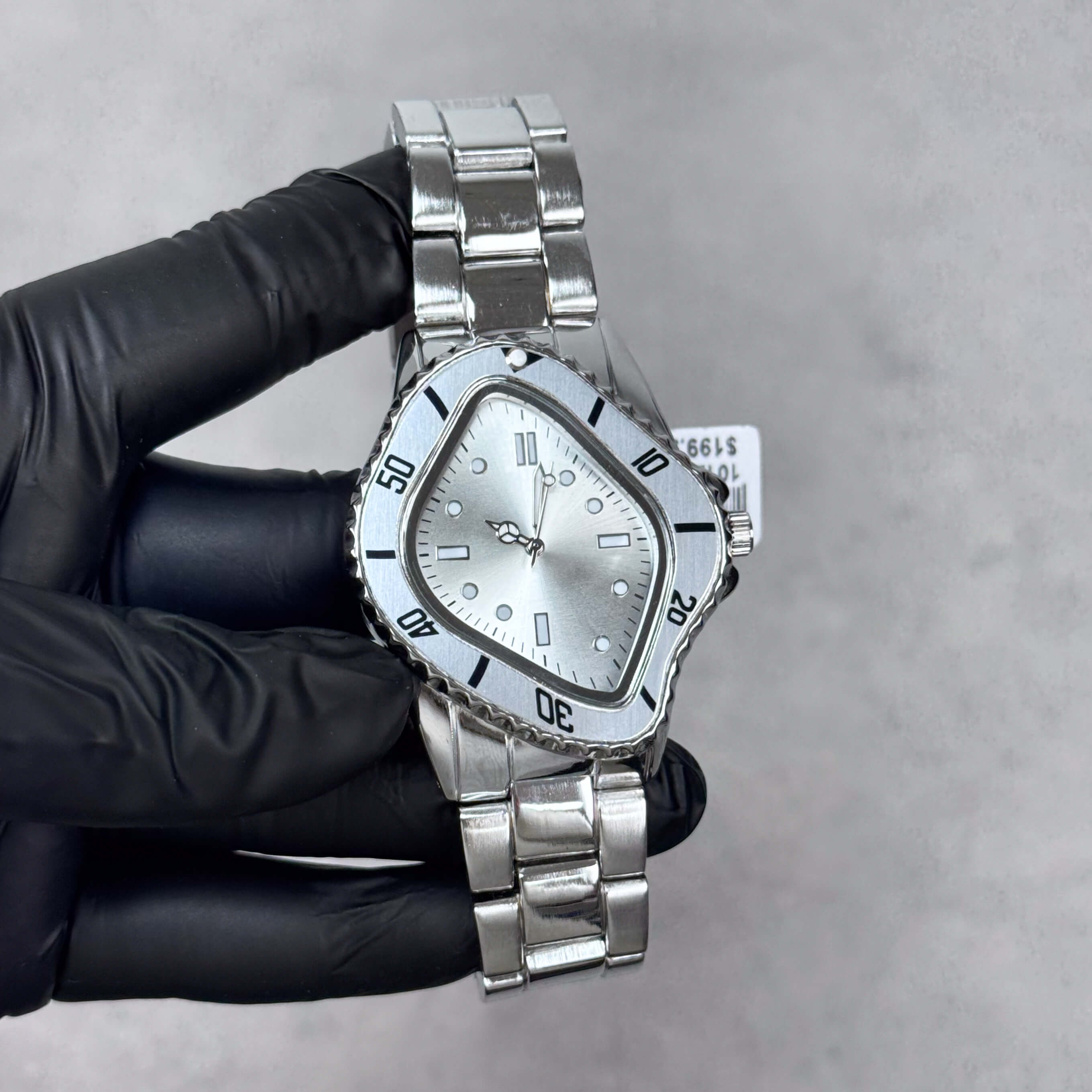 Silver Men’s 42mm warped case watch with silver dial, black accents, and metal link bracelet.