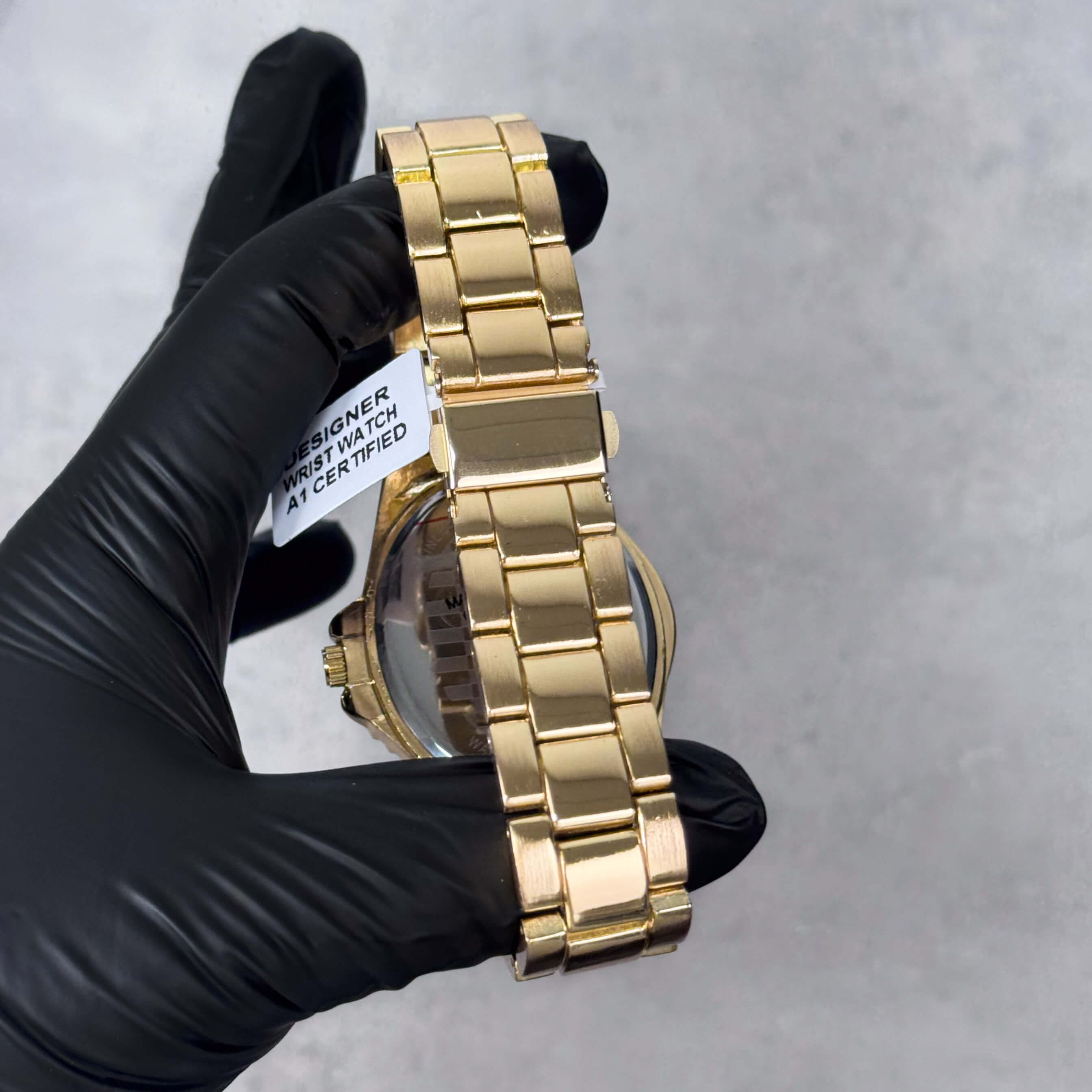 Close-up of gold metal band on Men’s 42mm warped case watch showcasing polished link design.