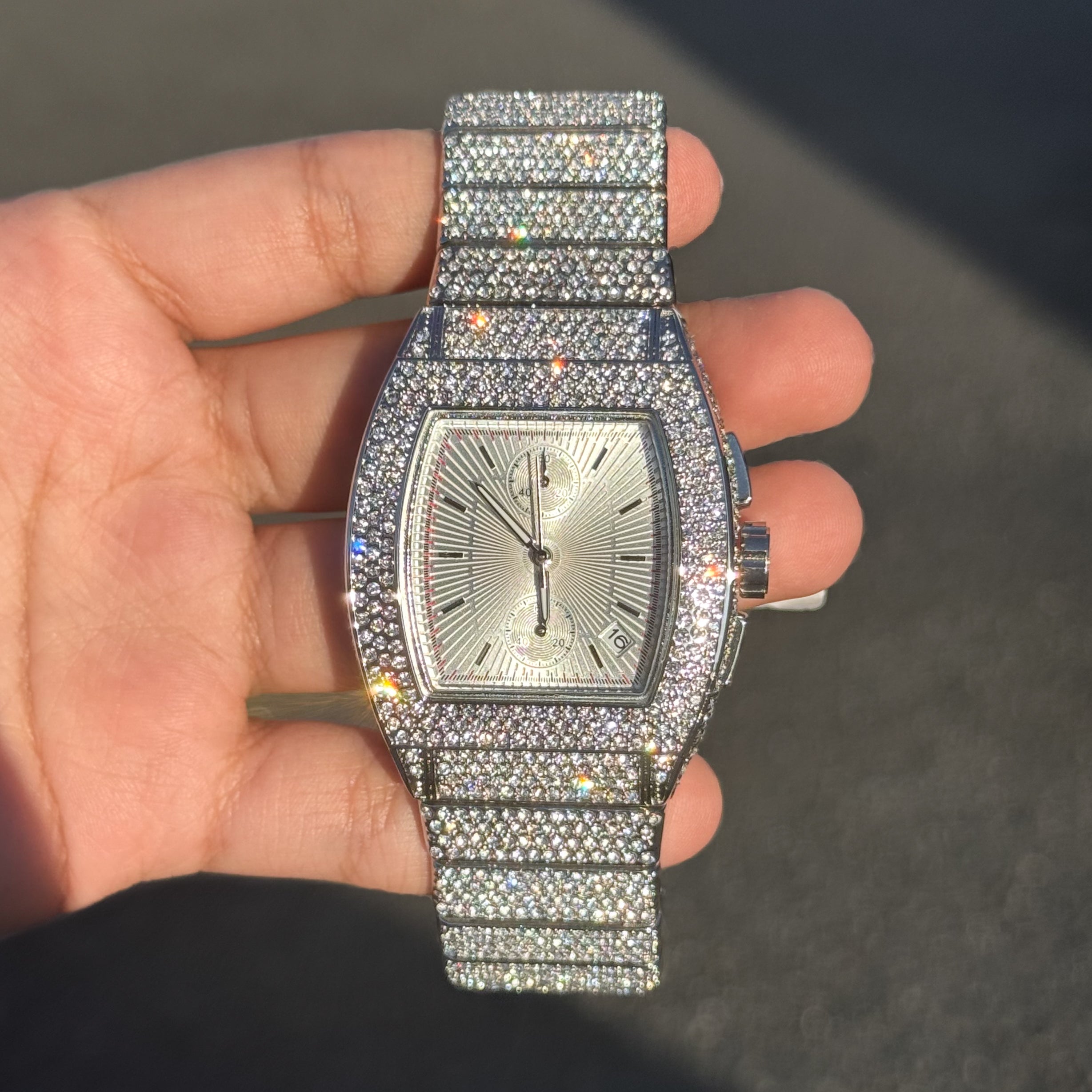 Men's 39mm silver iced out tonneau watch with full diamond setting and sunburst chronograph dial.