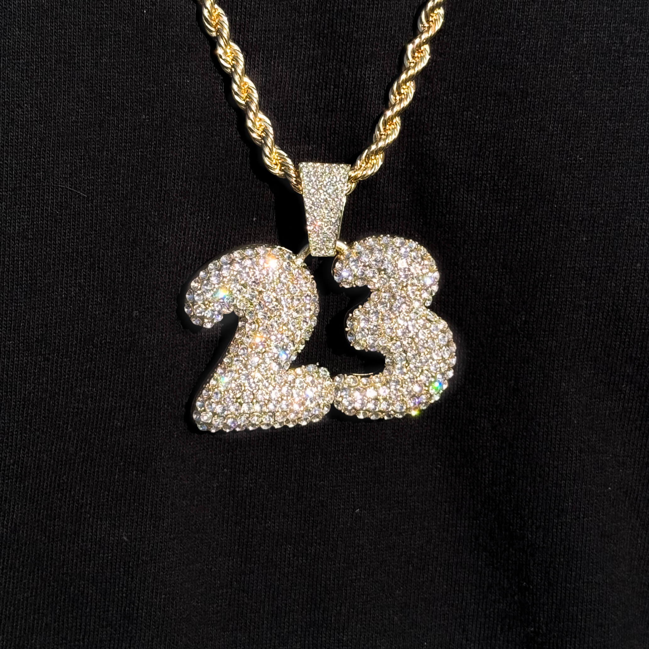 Gold Men's iced out Number 23 pendant on rope necklace shining with crystal stone accents.