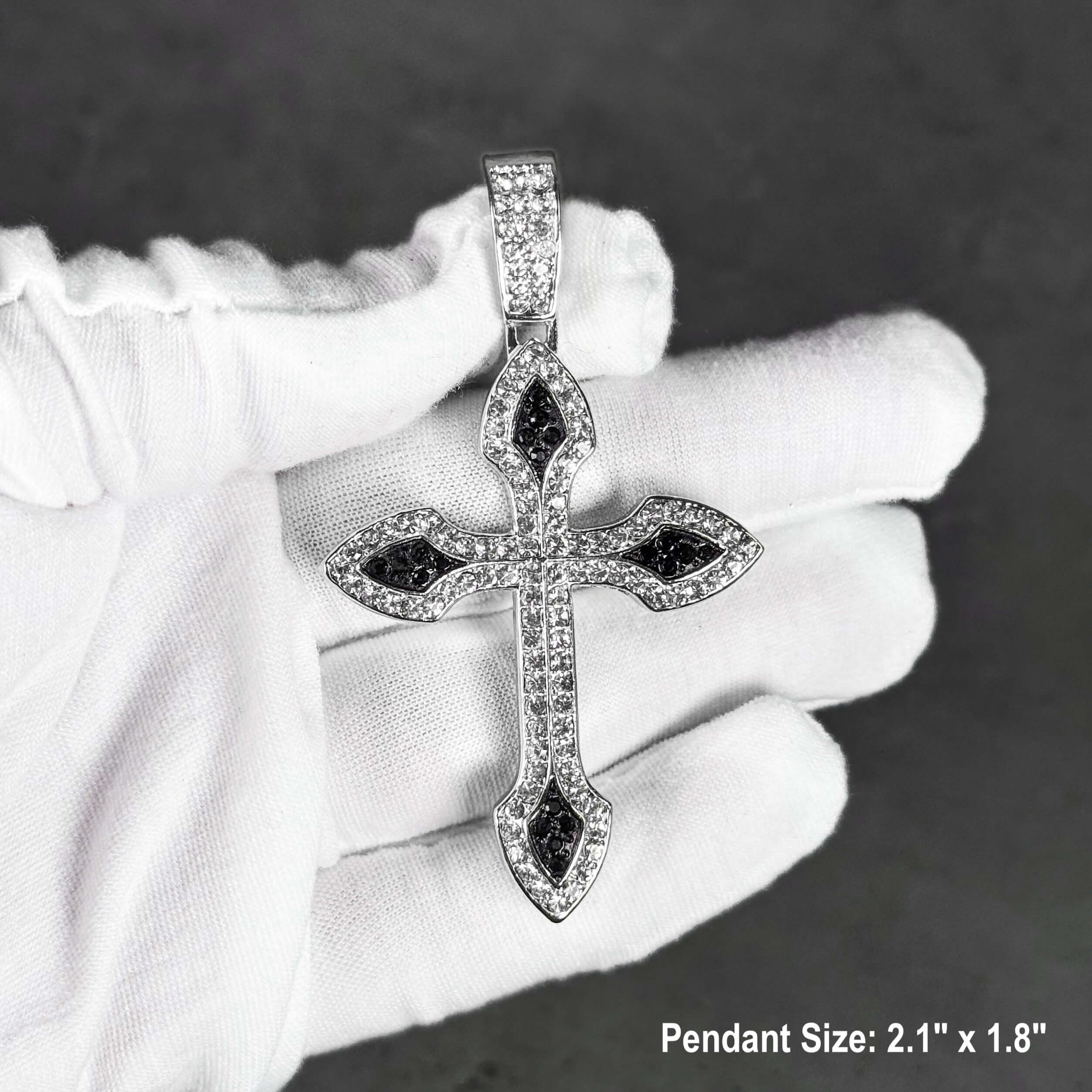Silver iced-out cross pendant with black stones, shown close-up to highlight detailed pavé design.