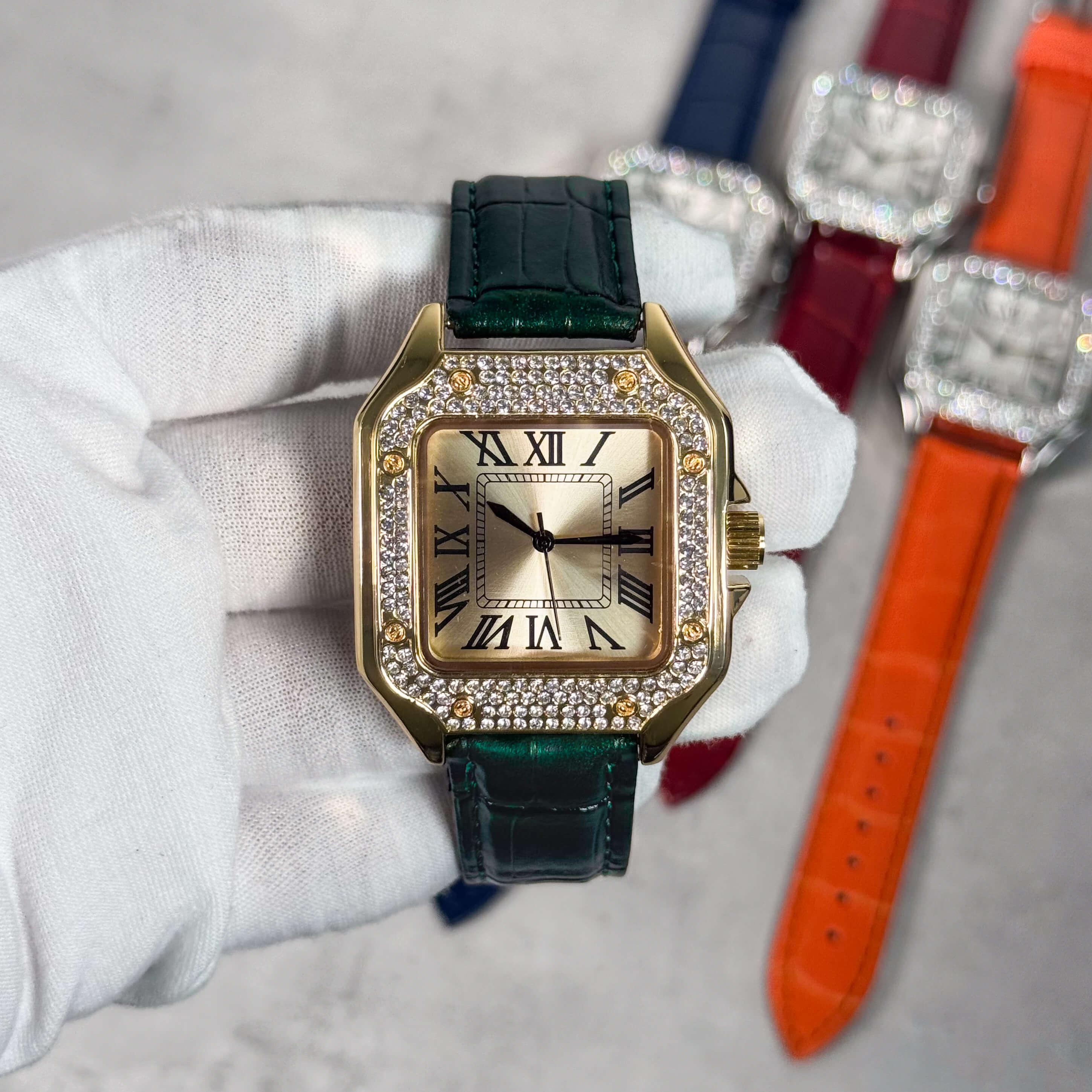 Men's 32mm square dial watch featuring gold case, crystal bezel and deep green leather band.