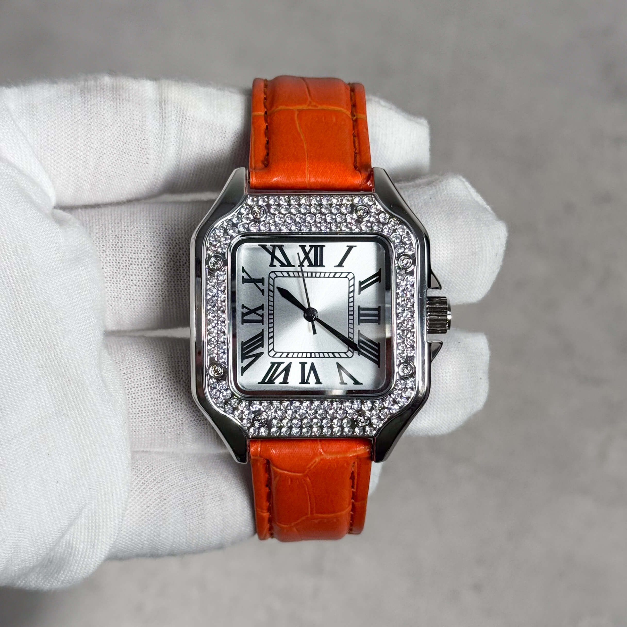 Men's 32mm square silver dial watch with crystal bezel paired with vibrant orange leather band.