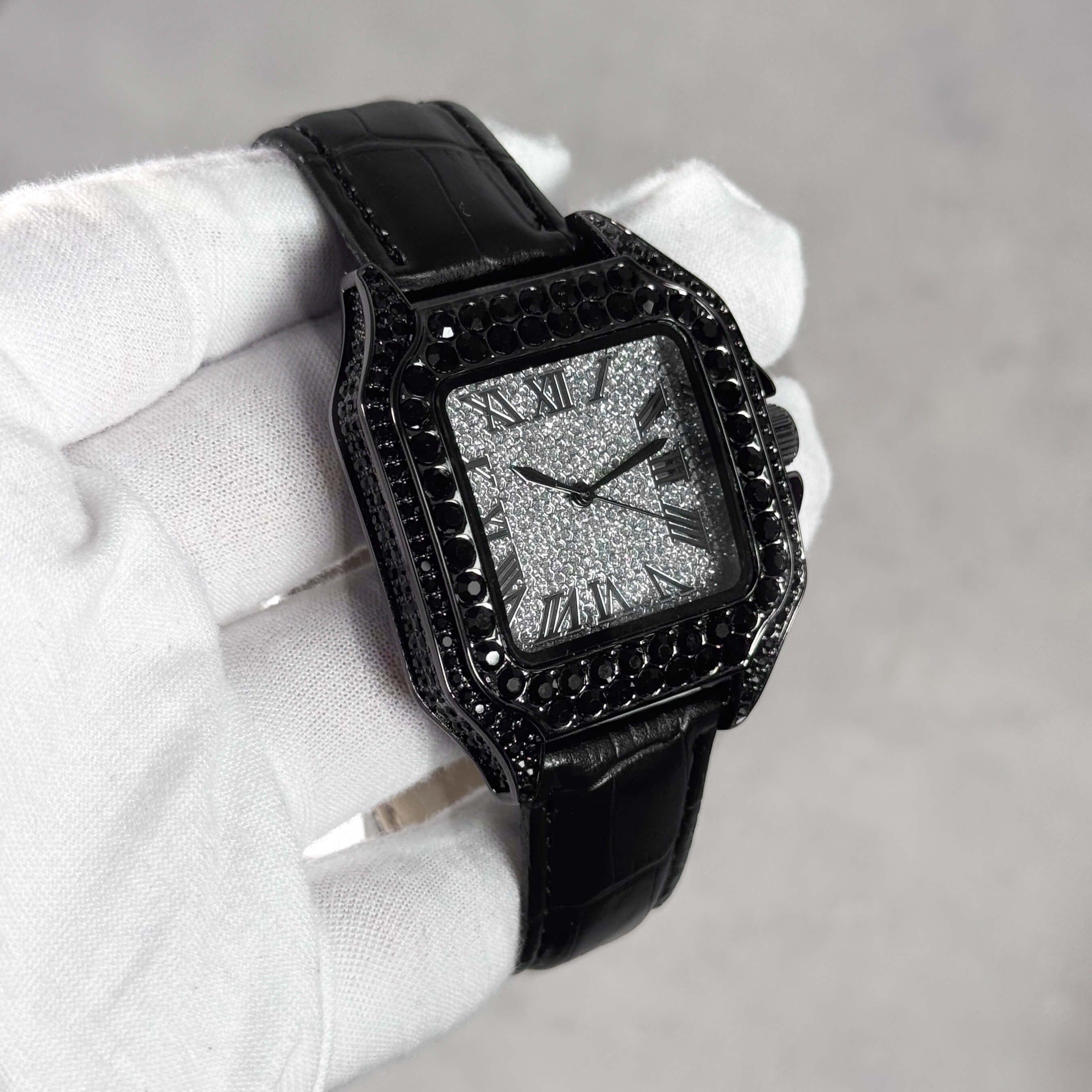 Men's 32mm black iced out square dial watch shown at an angle with black stones and leather strap.