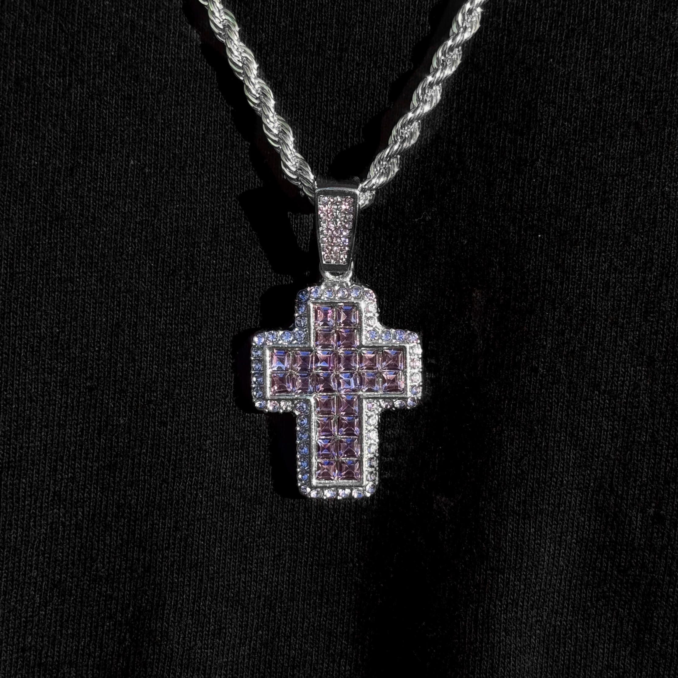 Silver purple stone cross pendant with iced-out border on men's 5mm rope chain necklace.