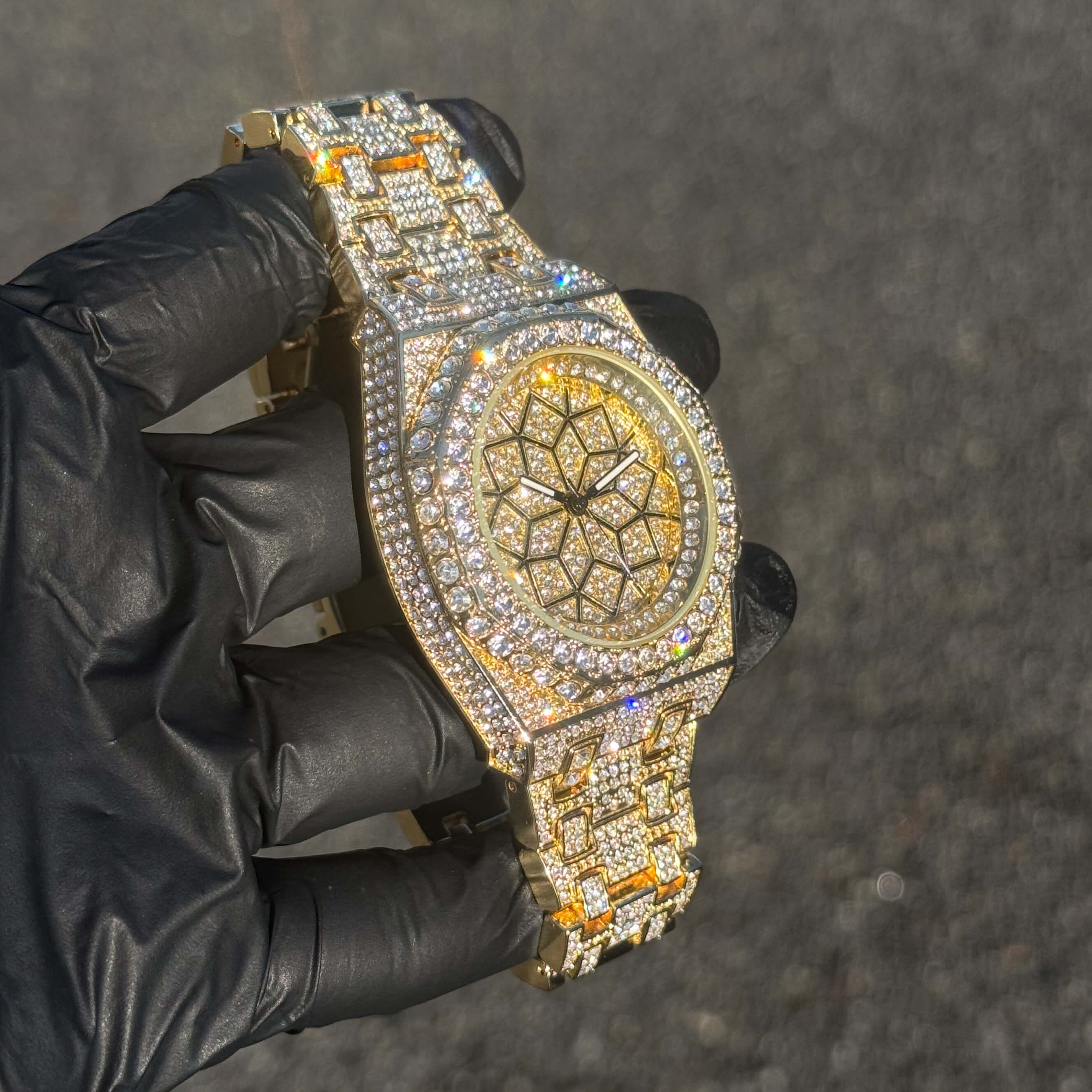 Men's 43mm gold iced out octagon watch shown at an angle with sparkling crystals and bracelet.
