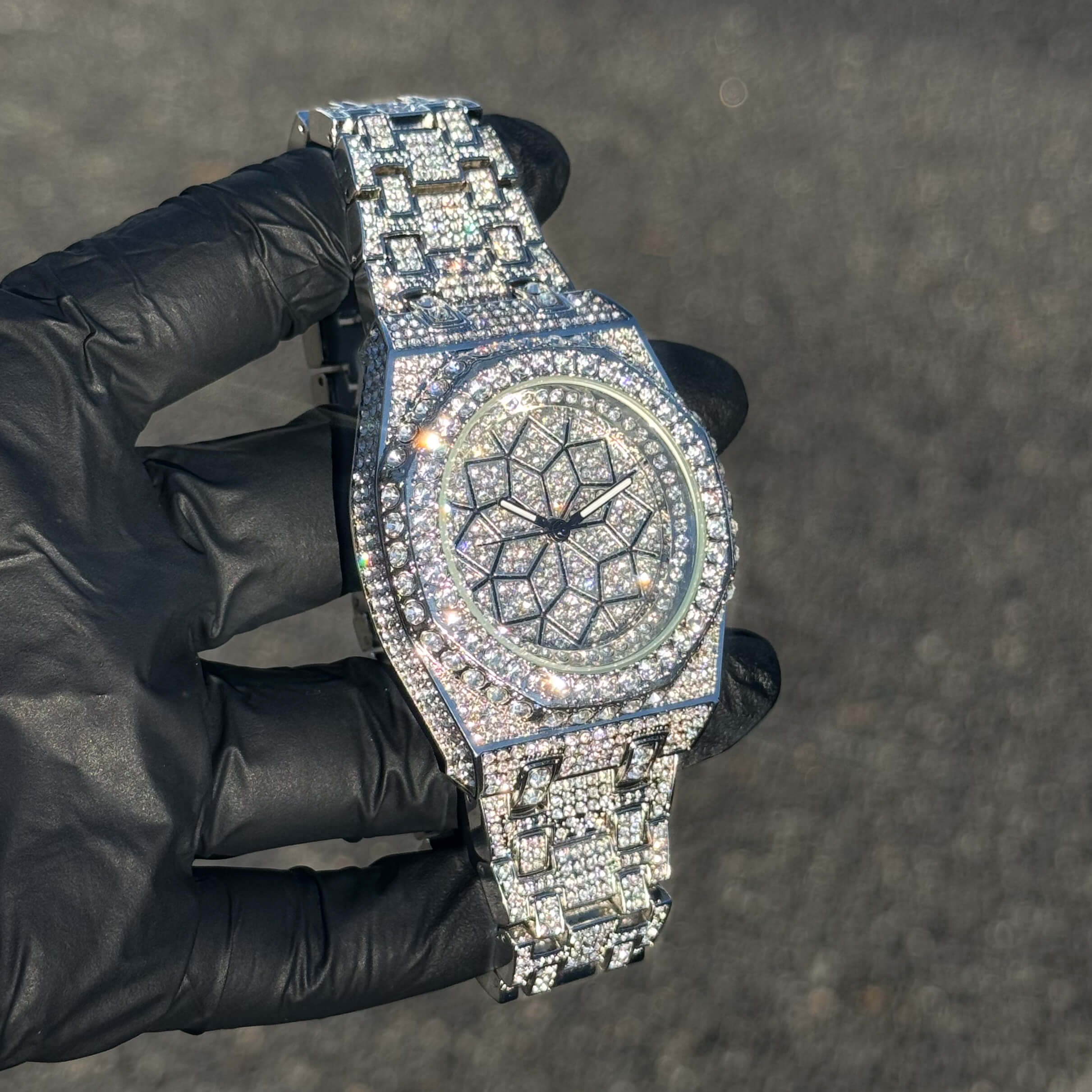 Men's 43mm silver iced out octagon watch displayed at an angle with crystal-covered bracelet.