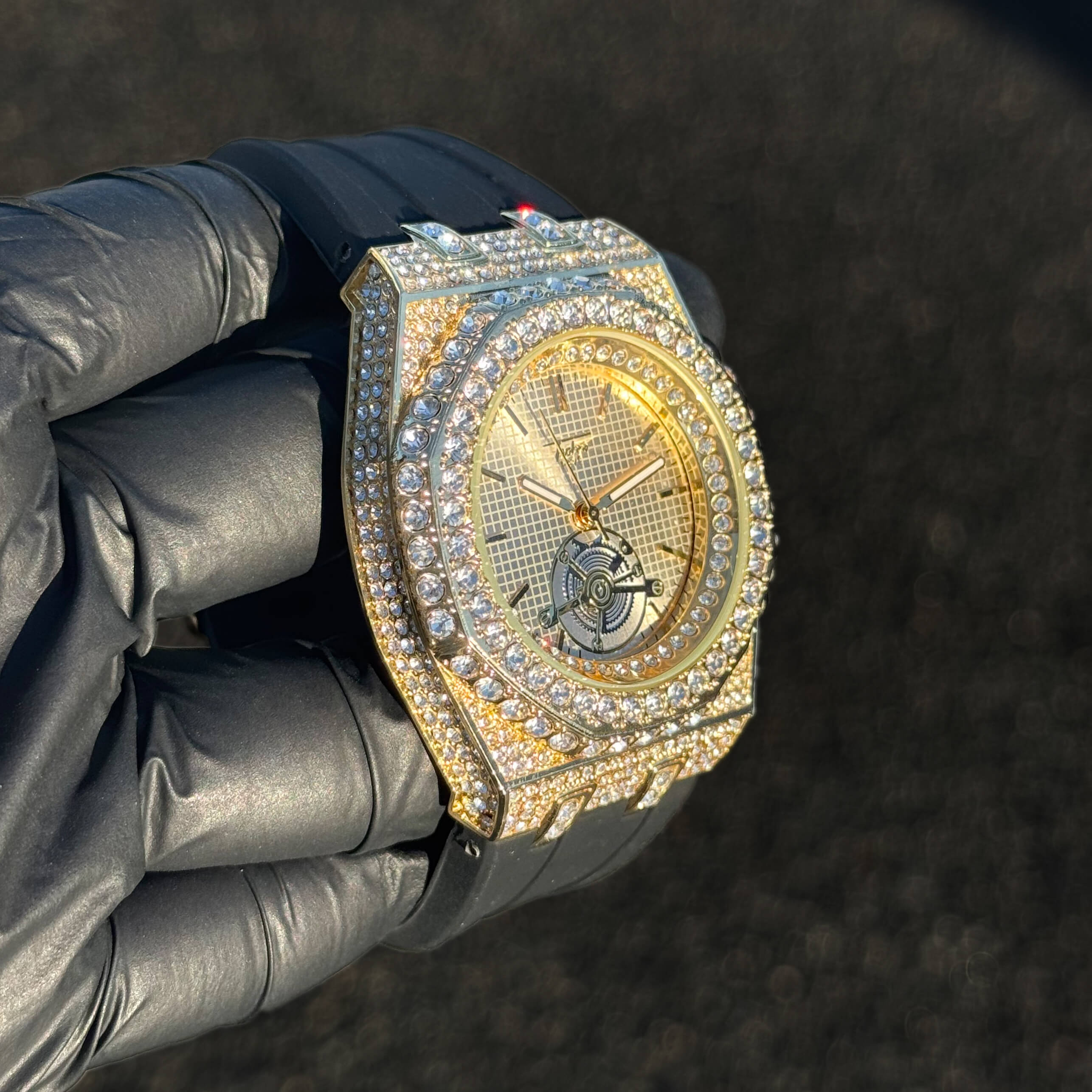 Men's 43mm gold iced out octagonal watch shown at an angle with crystal bezel and silicone strap.