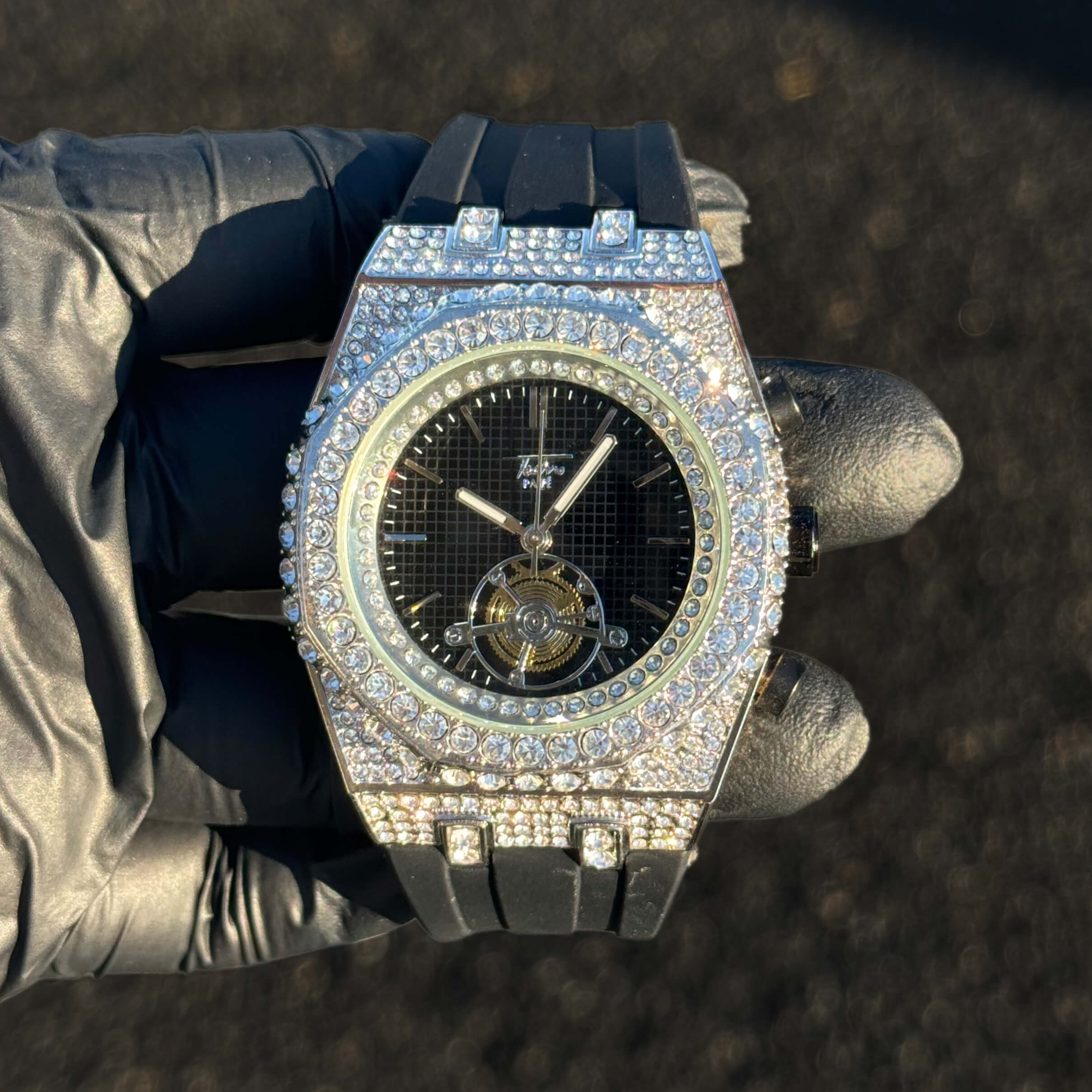 Men's 43mm iced out octagonal watch with black dial, silver crystal bezel, and silicone strap.