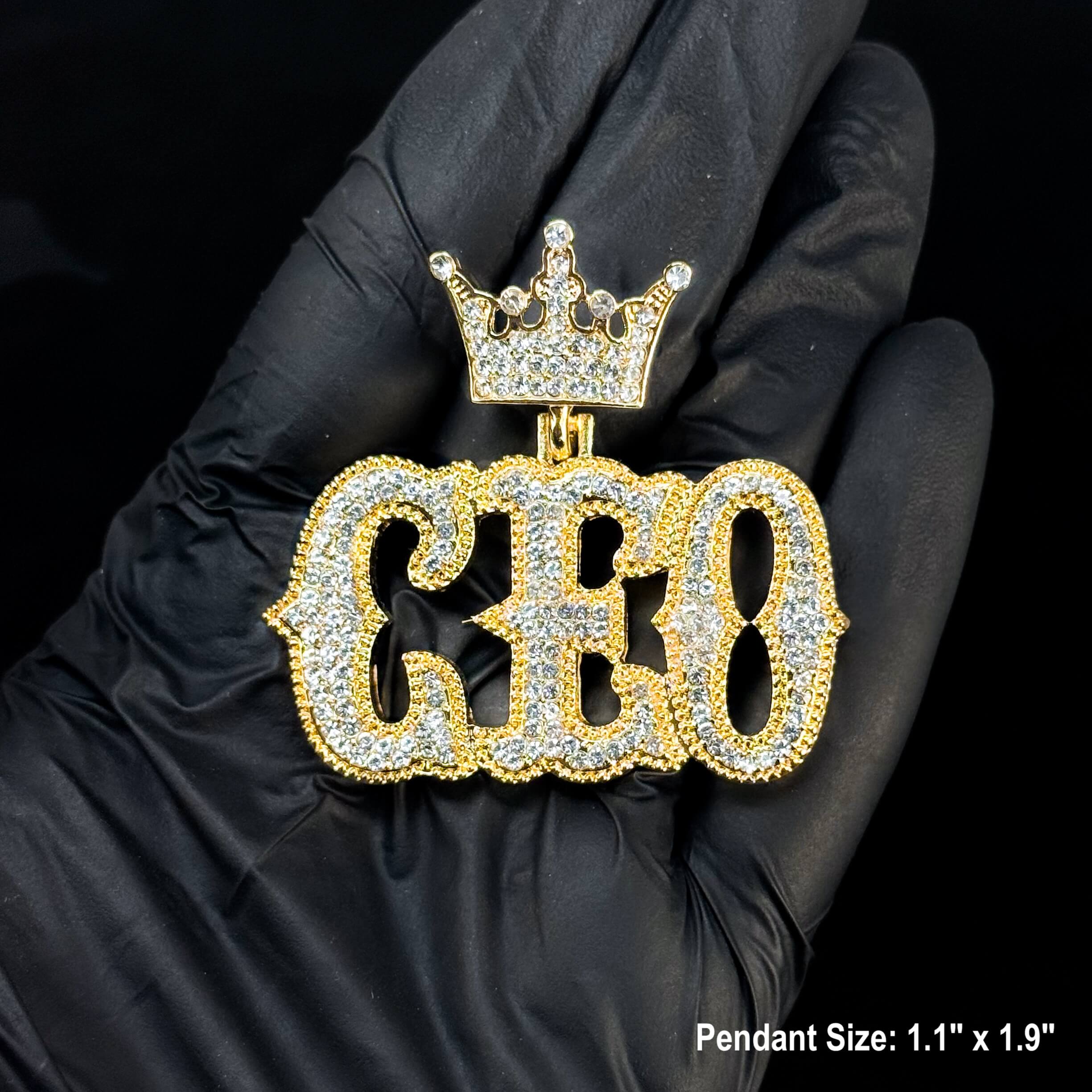 Gold Men's Iced Out CEO Pendant shown in hand with crown top and full crystal detailing, hip hop jewelry.