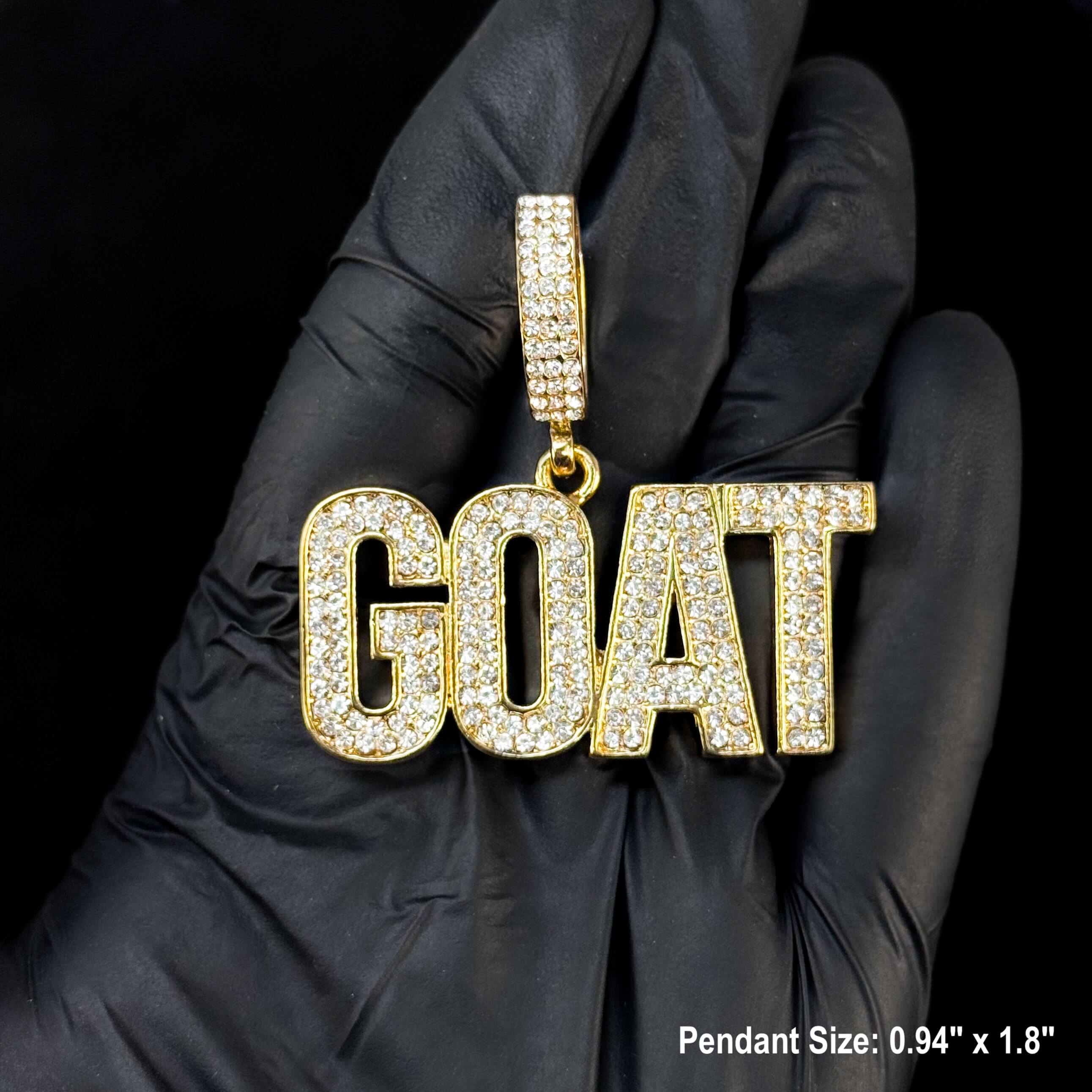 Gold iced-out GOAT pendant close-up showing sparkling stones and detailed letter design