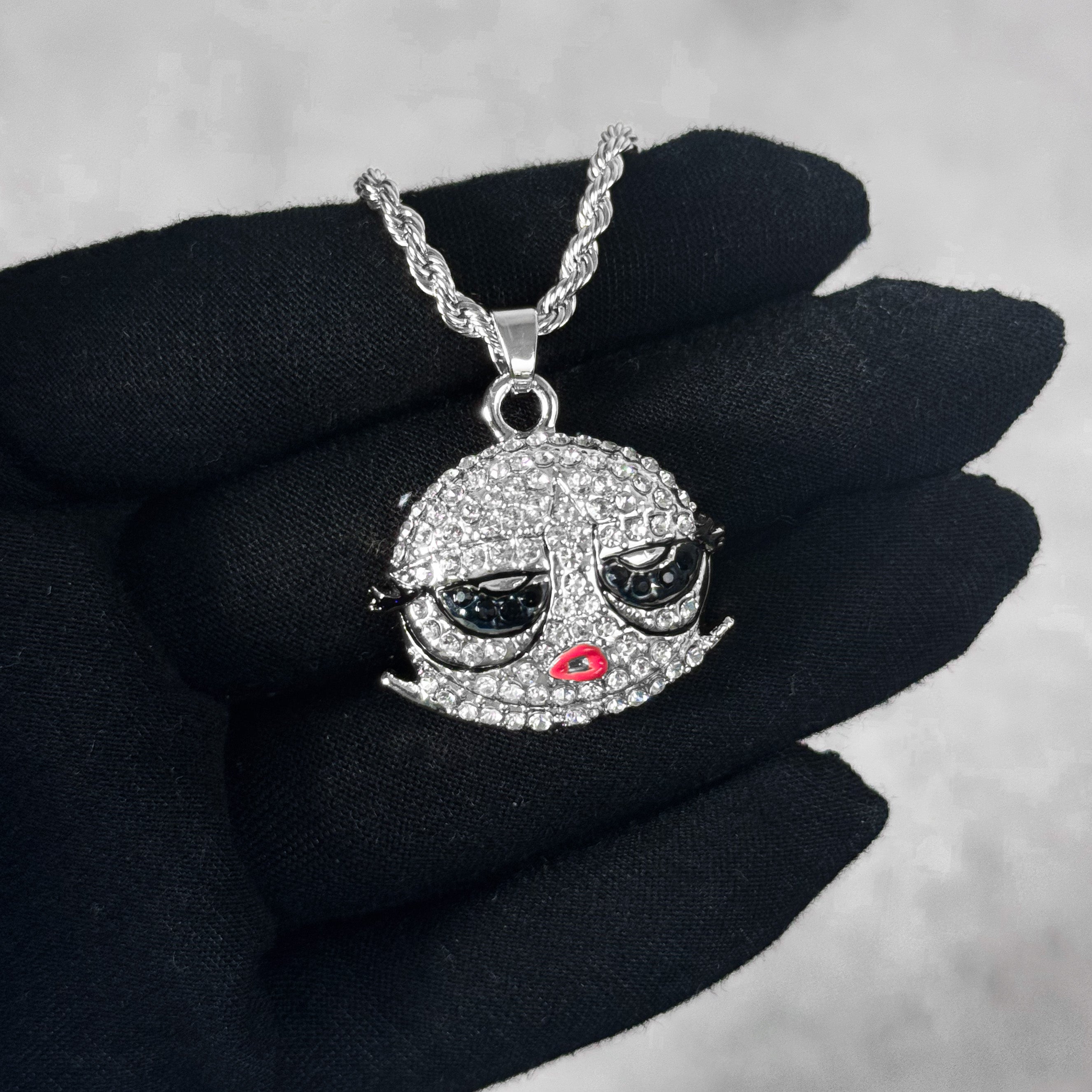 Mini Iced Out Bob Doll Pendant in silver finish with rhinestone details, shown on hand for scale.