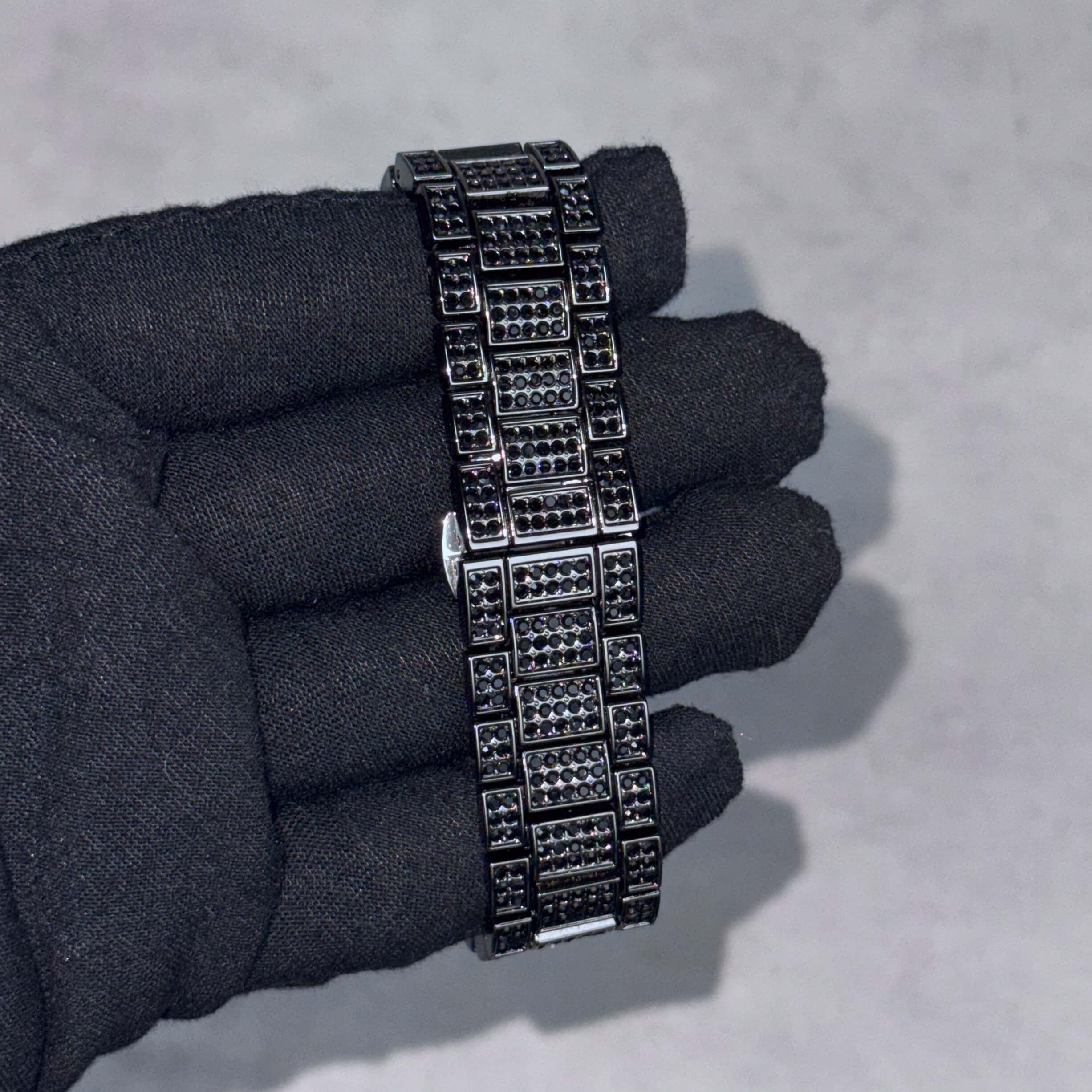Fully iced-out black watch bracelet featuring multi-row crystal links for men’s luxury warped watch.