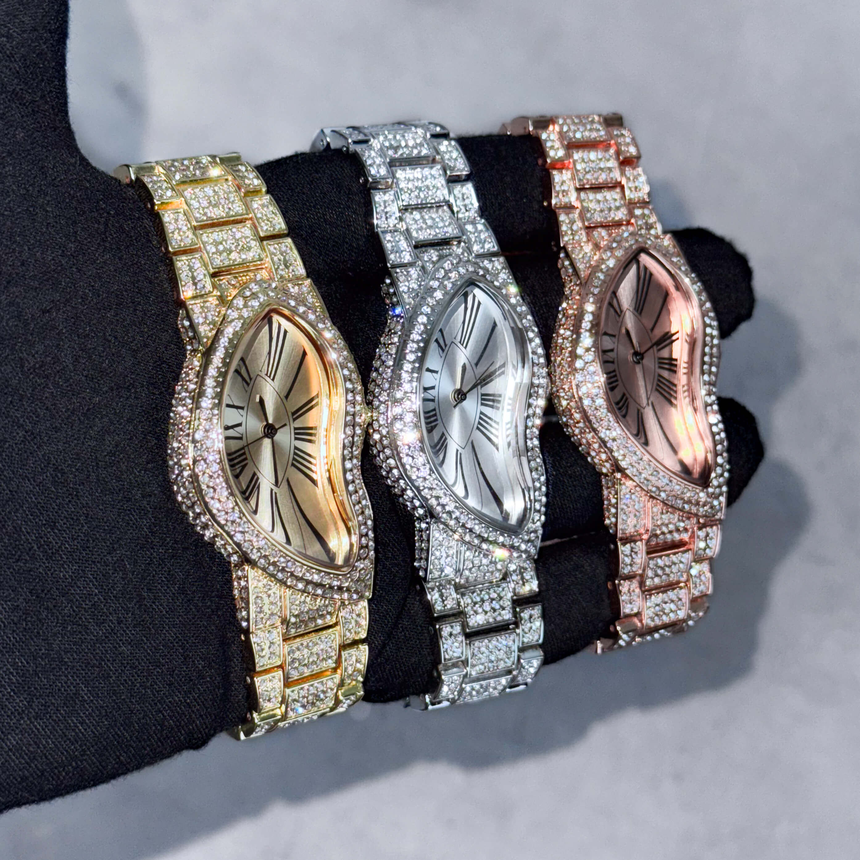 Men's 30mm iced-out warped watches in gold, silver and rose gold with pavé bezels and curved dials.