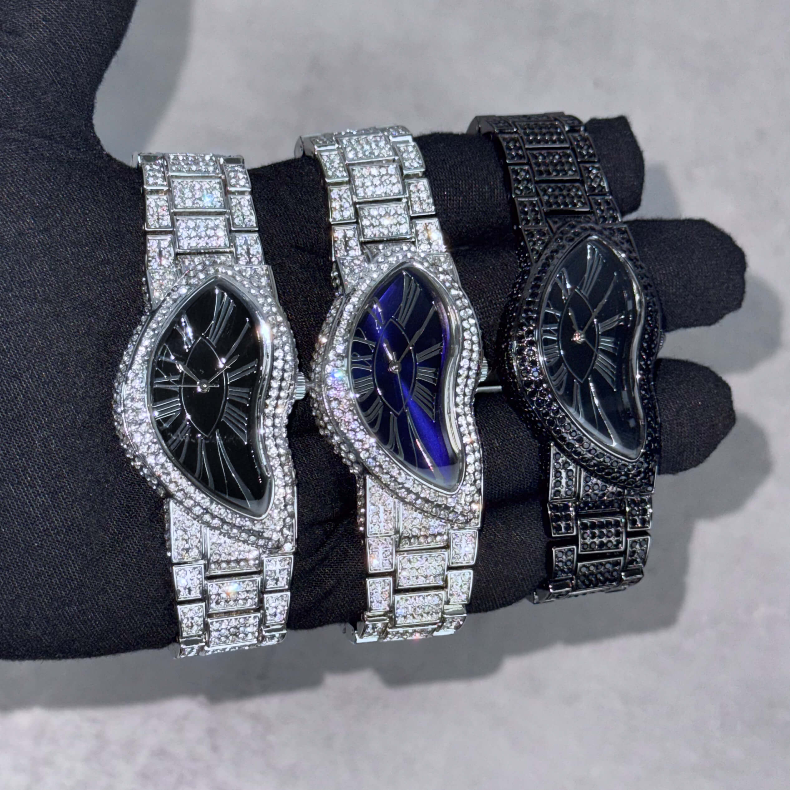 Men’s 30mm iced-out warped watches in black, blue dial and silver bracelet featuring full crystal detailing.