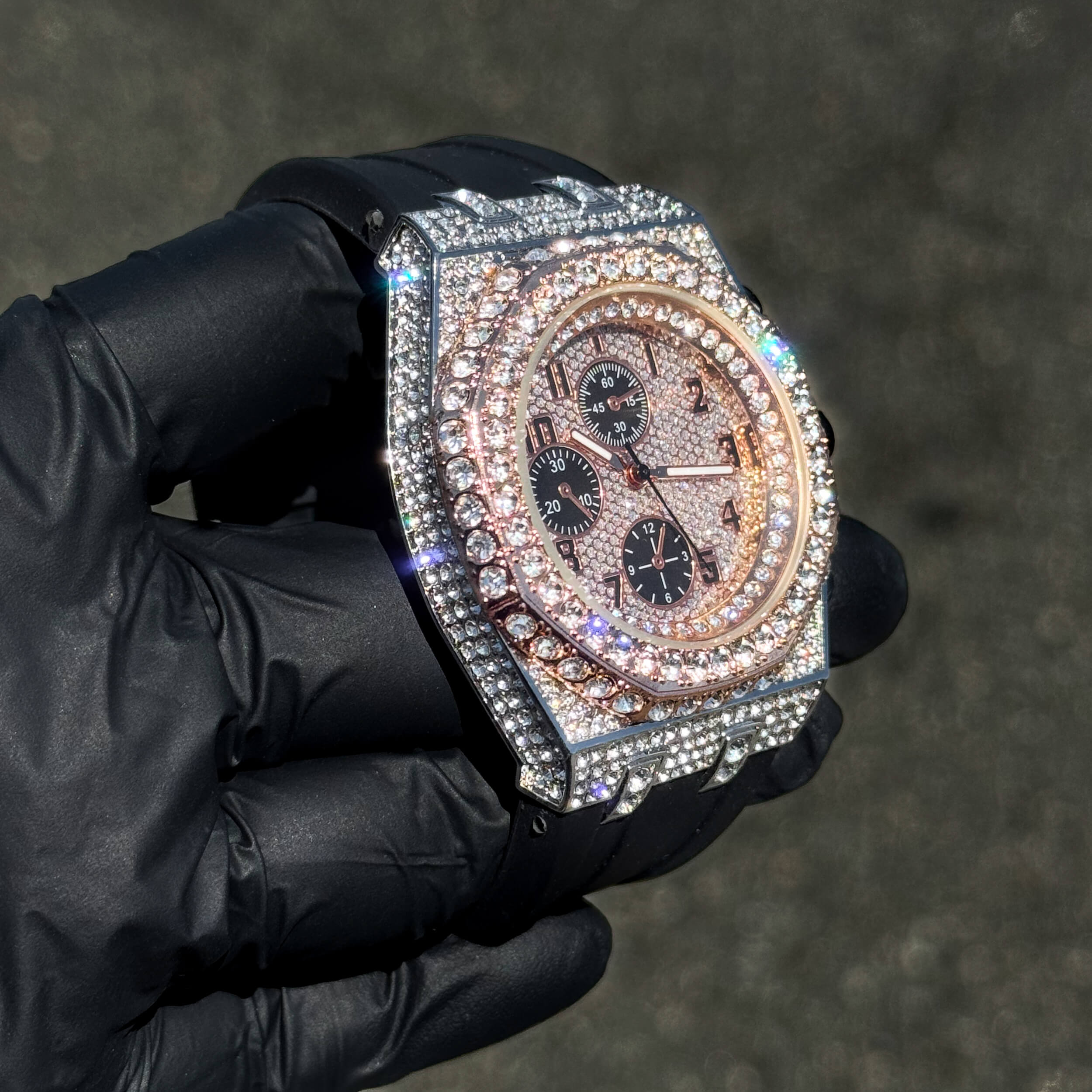 Men's 43mm rose gold iced out octagon bezel diamond watch with black silicone band and quartz dial.