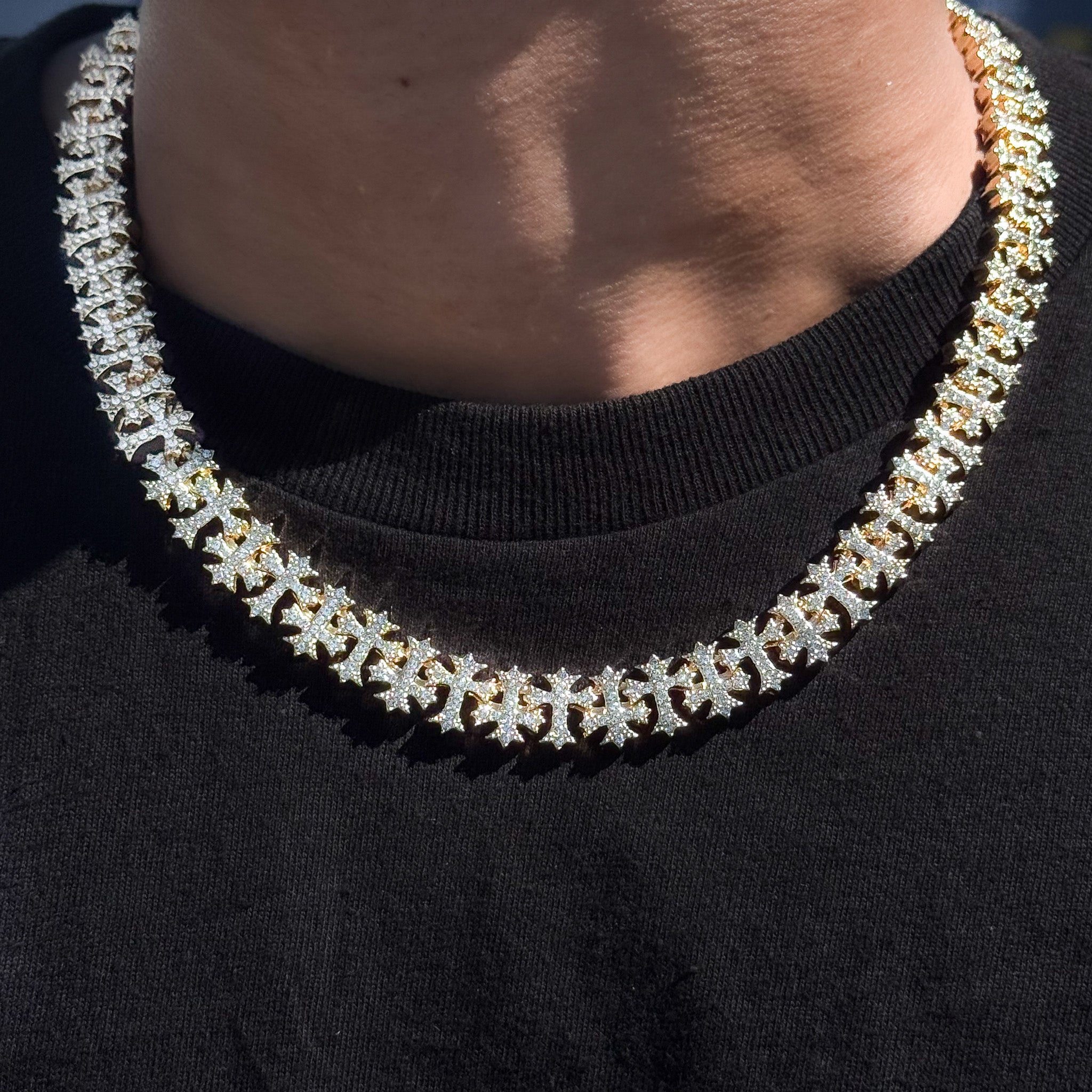 Men's 20mm iced out cross link chain necklace in gold, shown worn to showcase sparkle and craftsmanship.