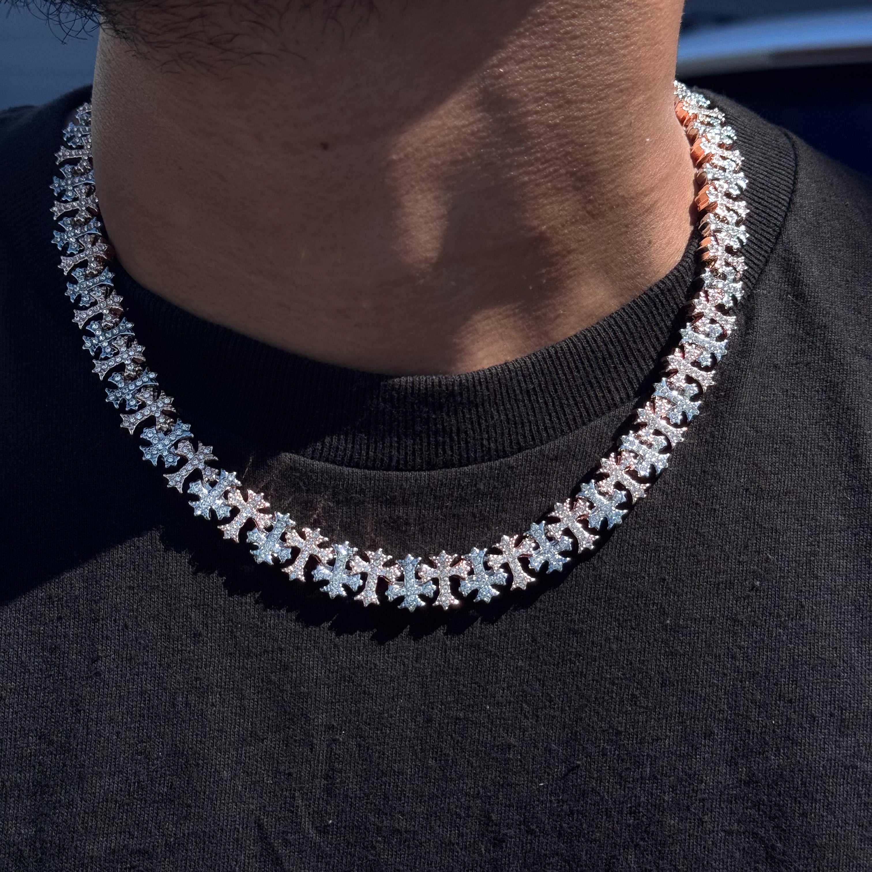 Men's 20mm iced out cross link chain necklace in silver and rose gold, shown worn for shine and detail.