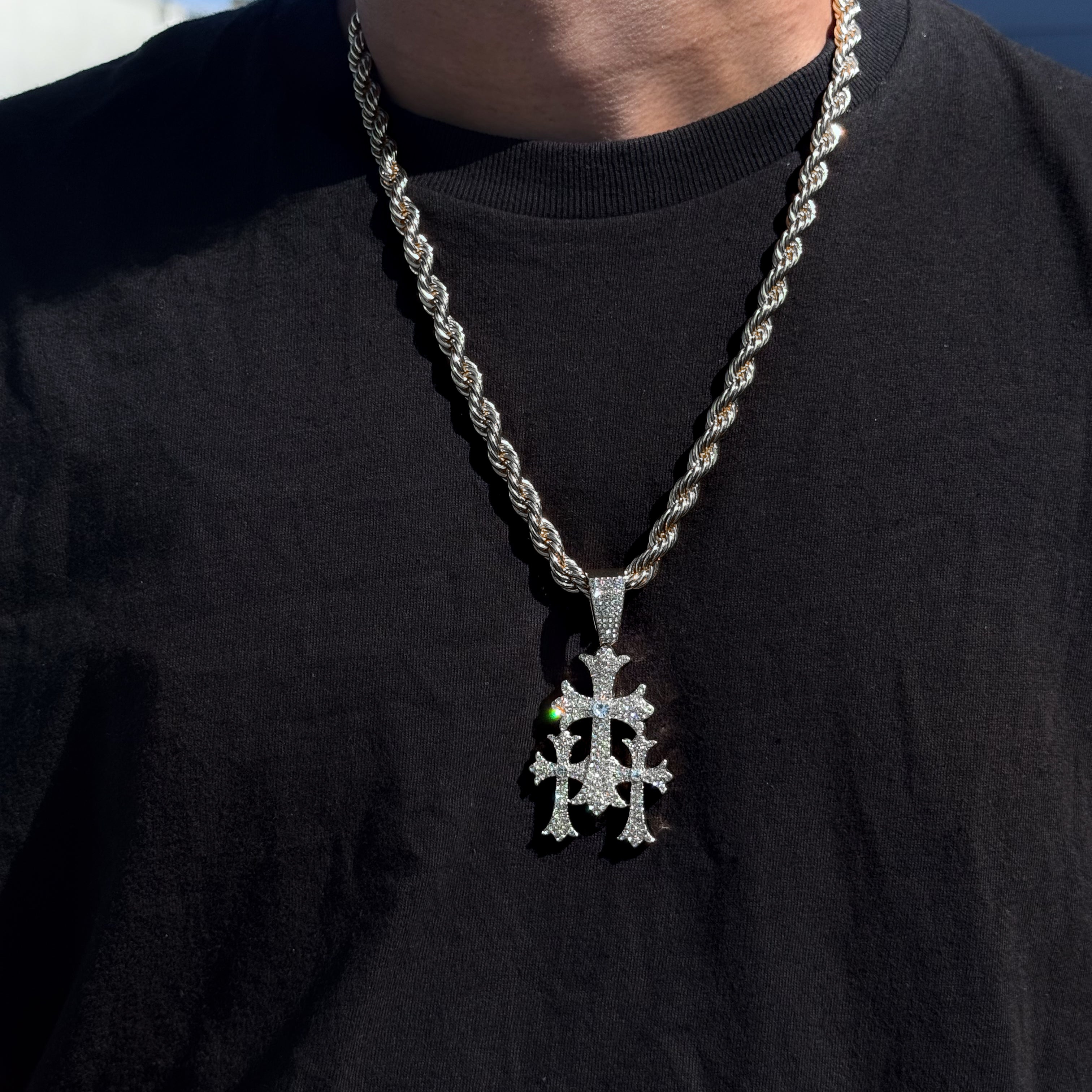 Men’s silver 40mm iced-out cross pendant with 8mm rope chain styled over black T-shirt.